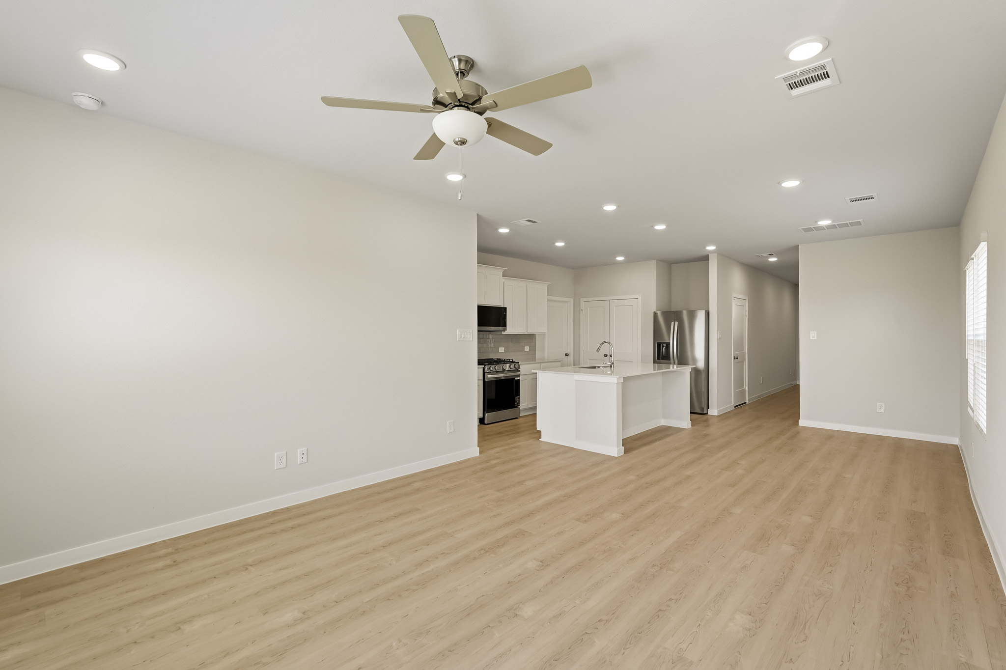 A large kitchen with a wood floor.