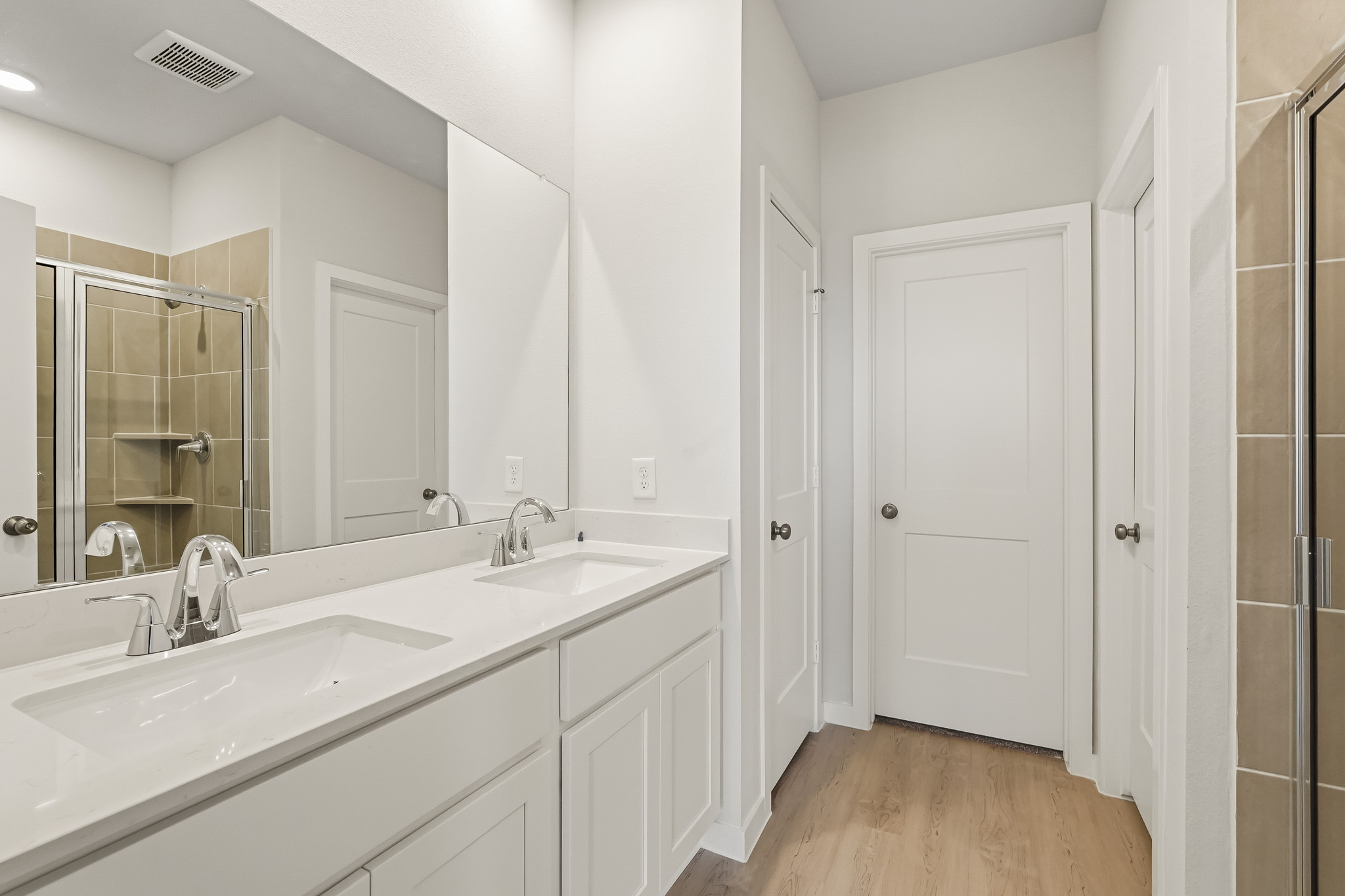 A bathroom with white cabinets.