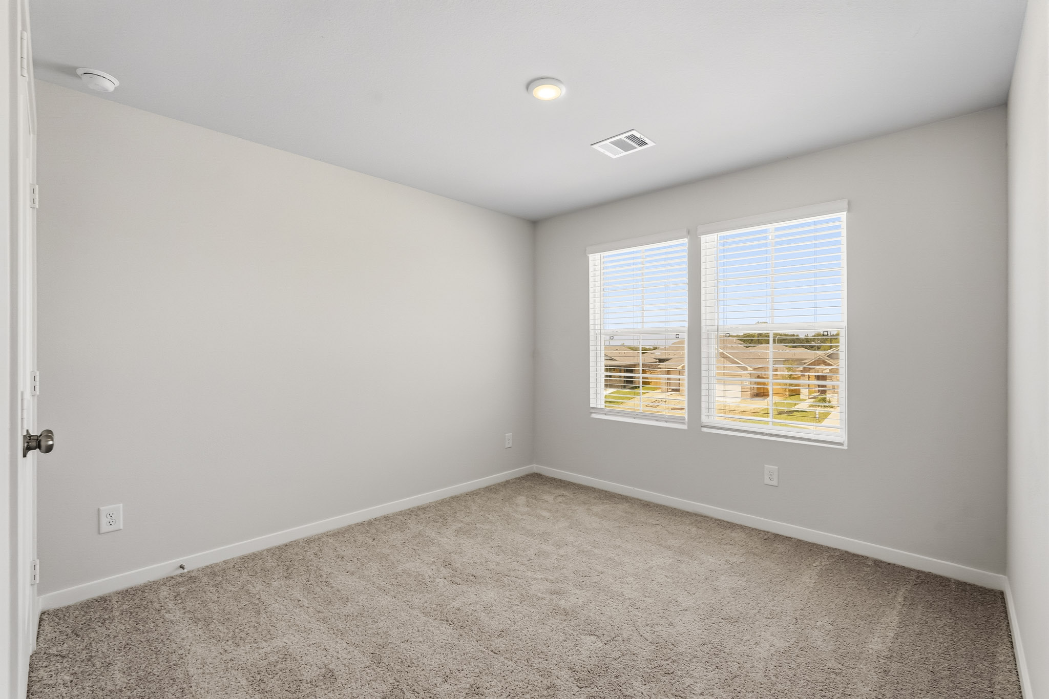 A room with a carpet and windows.