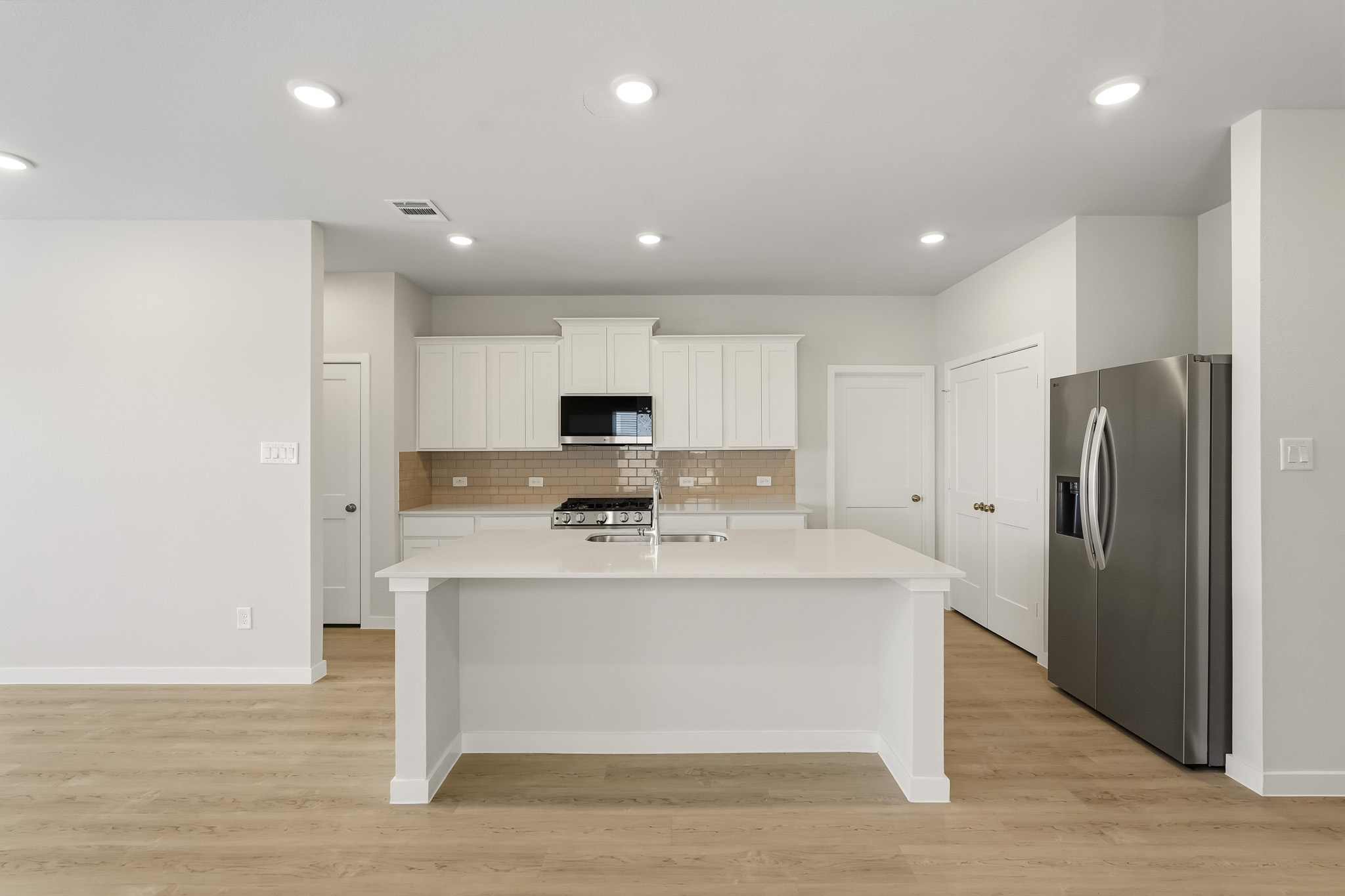 A kitchen with white cabinets.