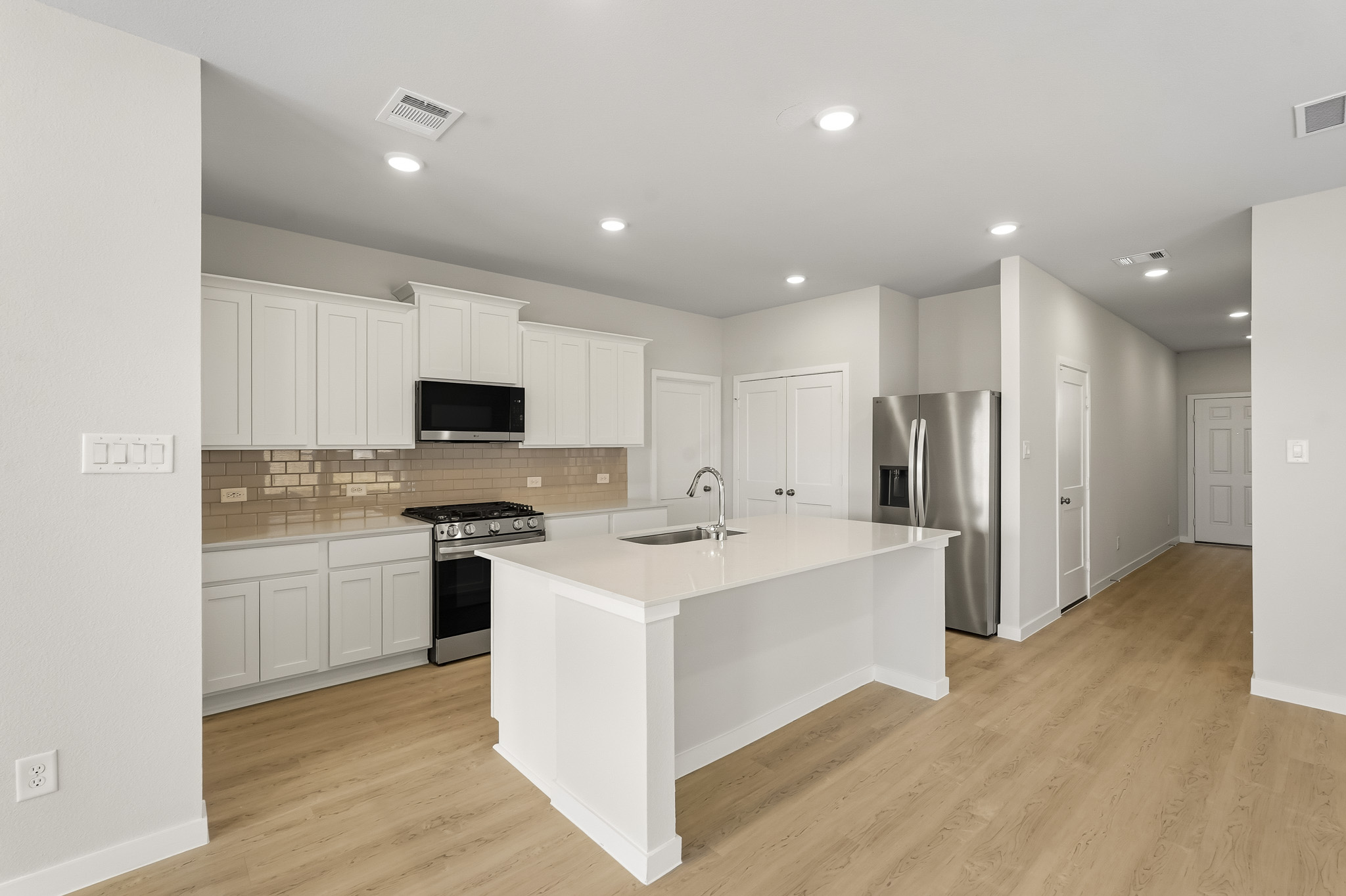 A kitchen with white cabinets.
