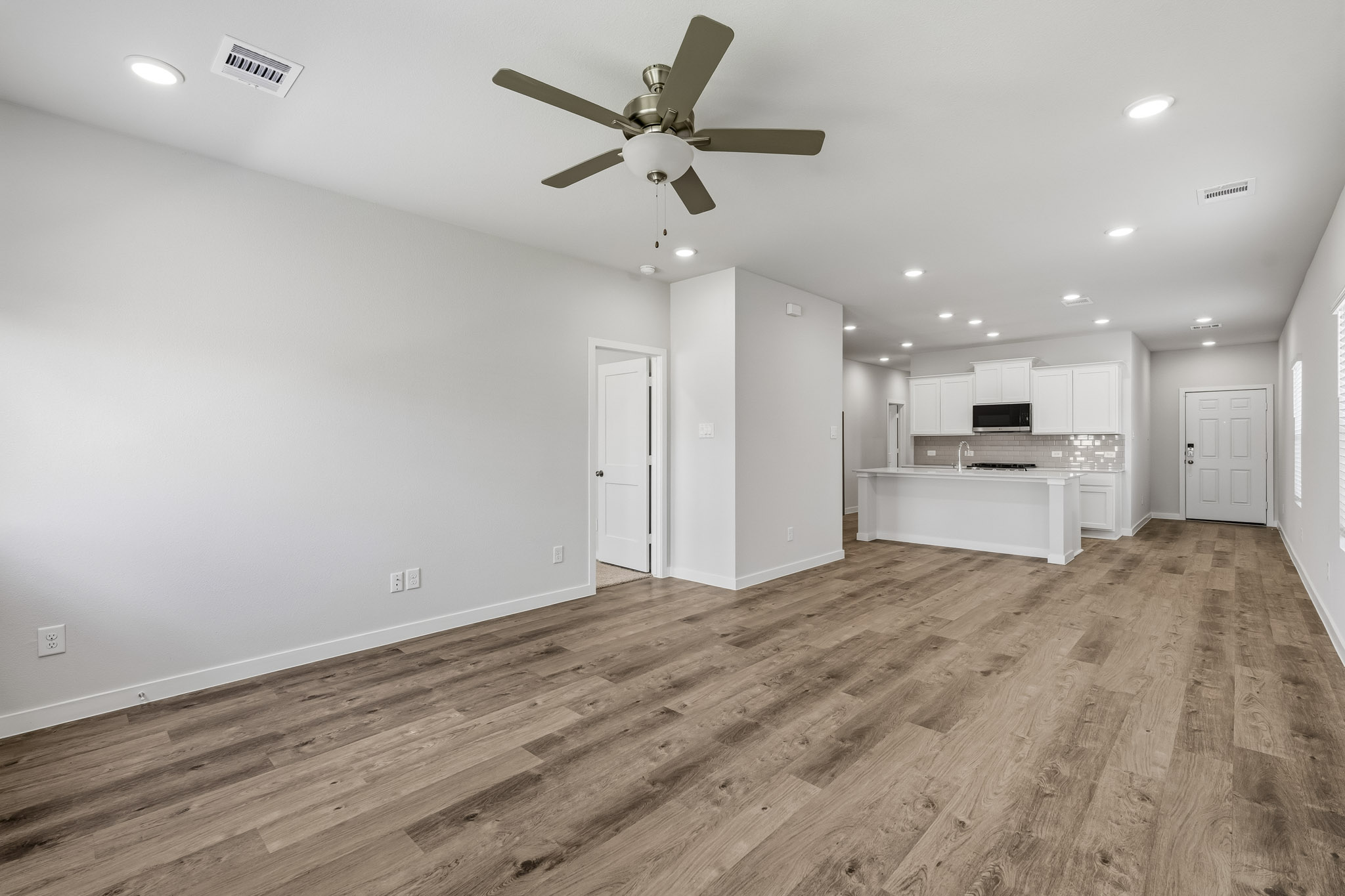 A room with a wood floor and a ceiling fan.