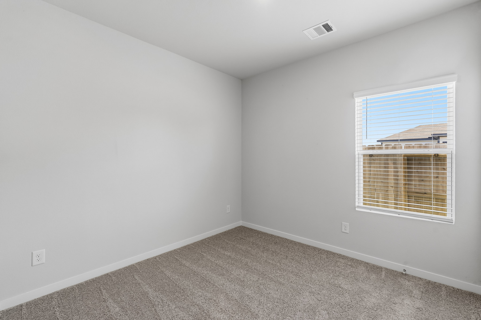 A room with a window and carpet.