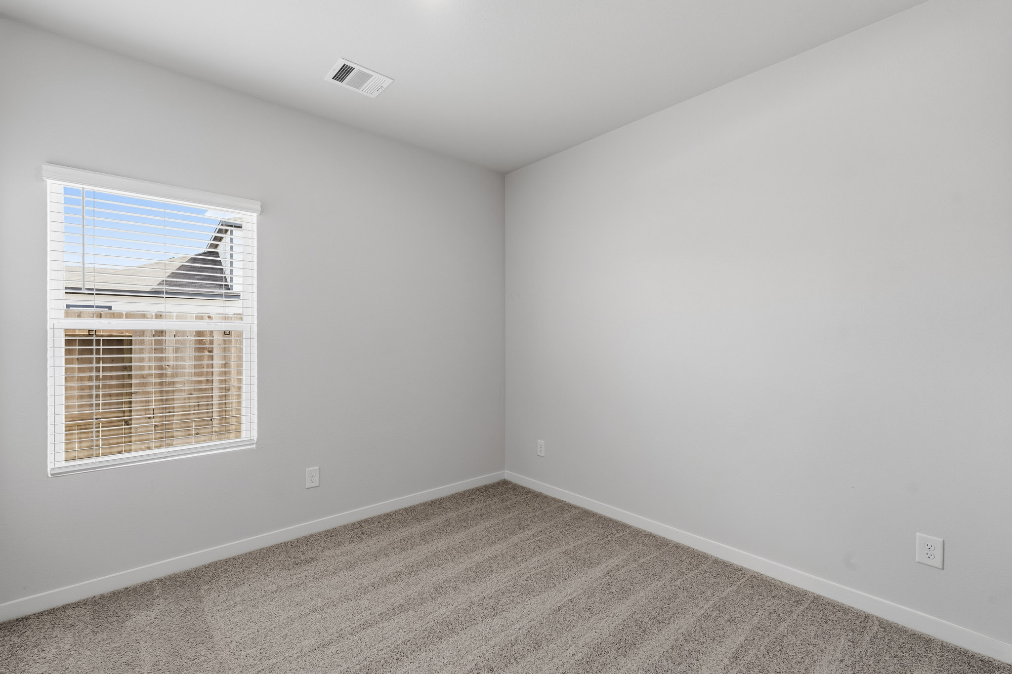 A room with a window and a carpet.