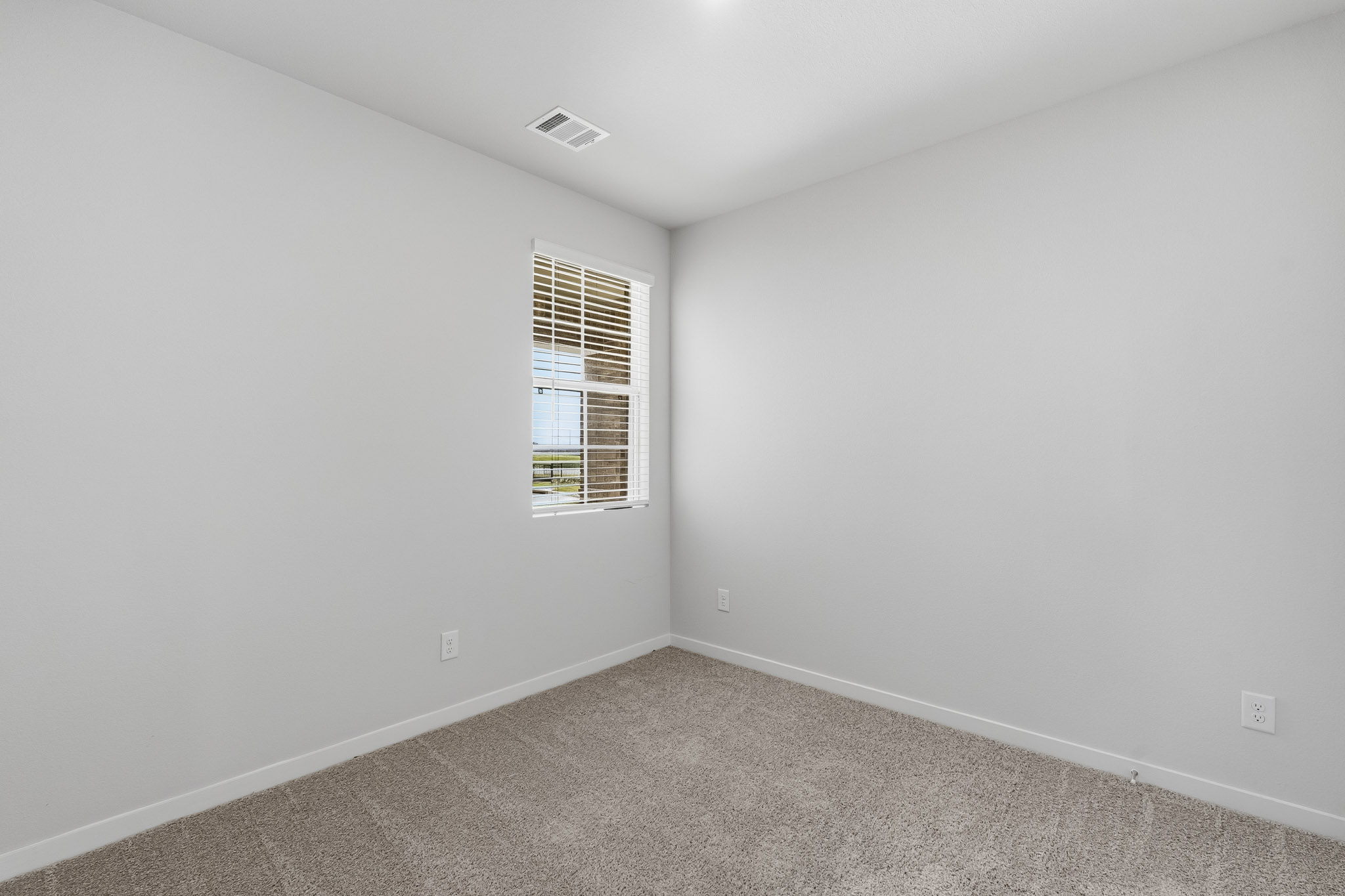 A room with a window and a carpet.