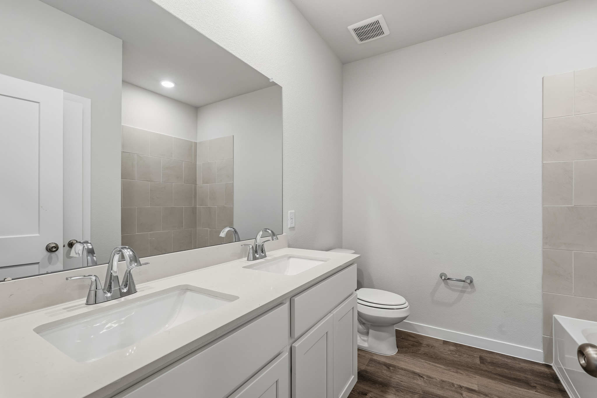 A bathroom with a large mirror.