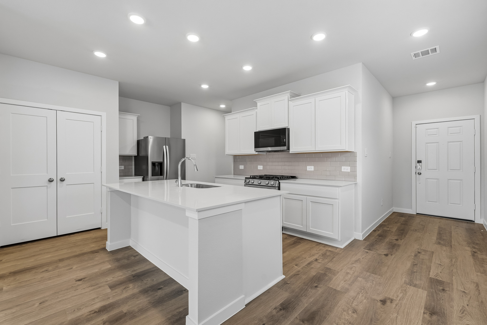 A kitchen with white cabinets.