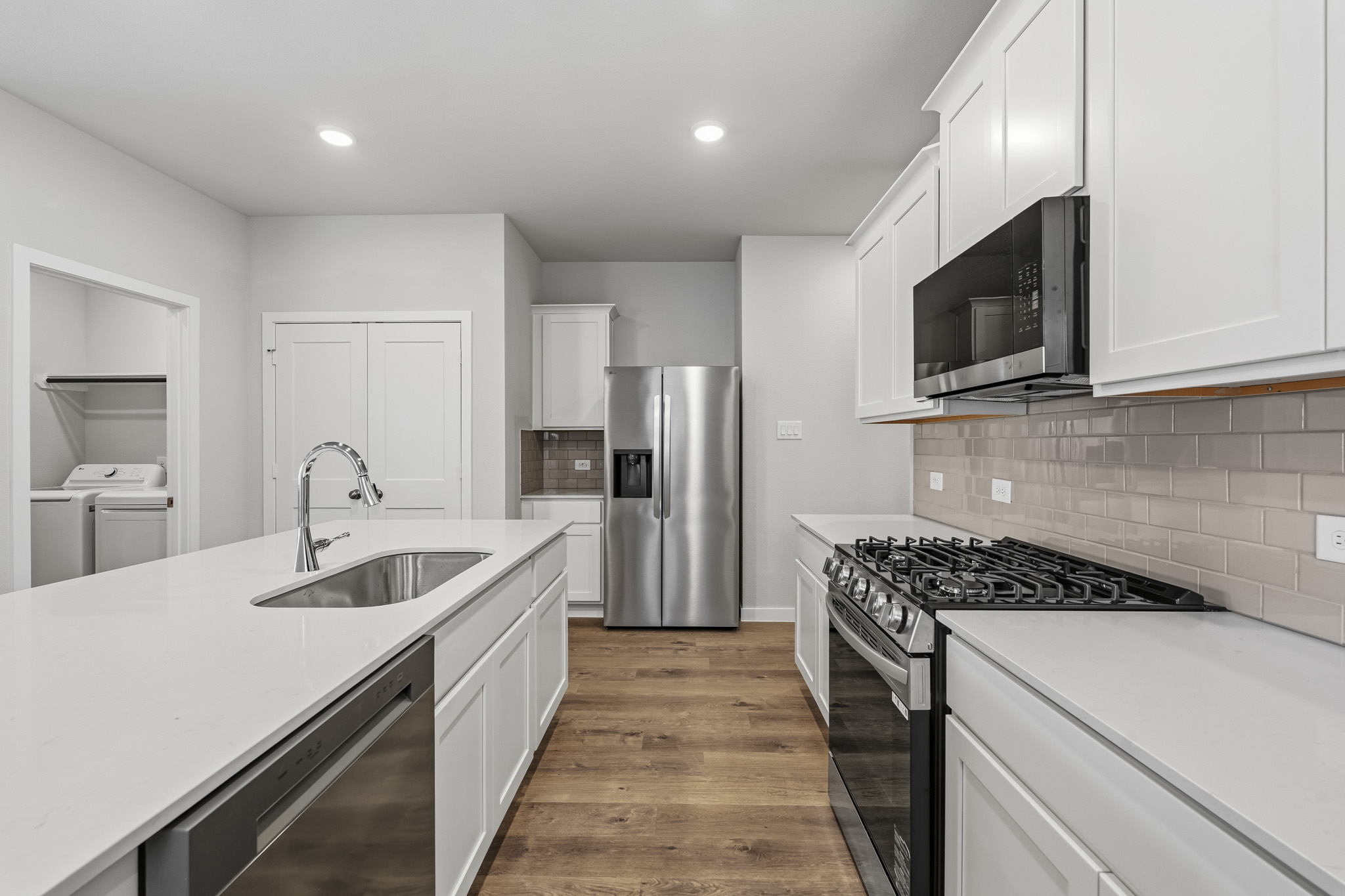 A kitchen with white cabinets.