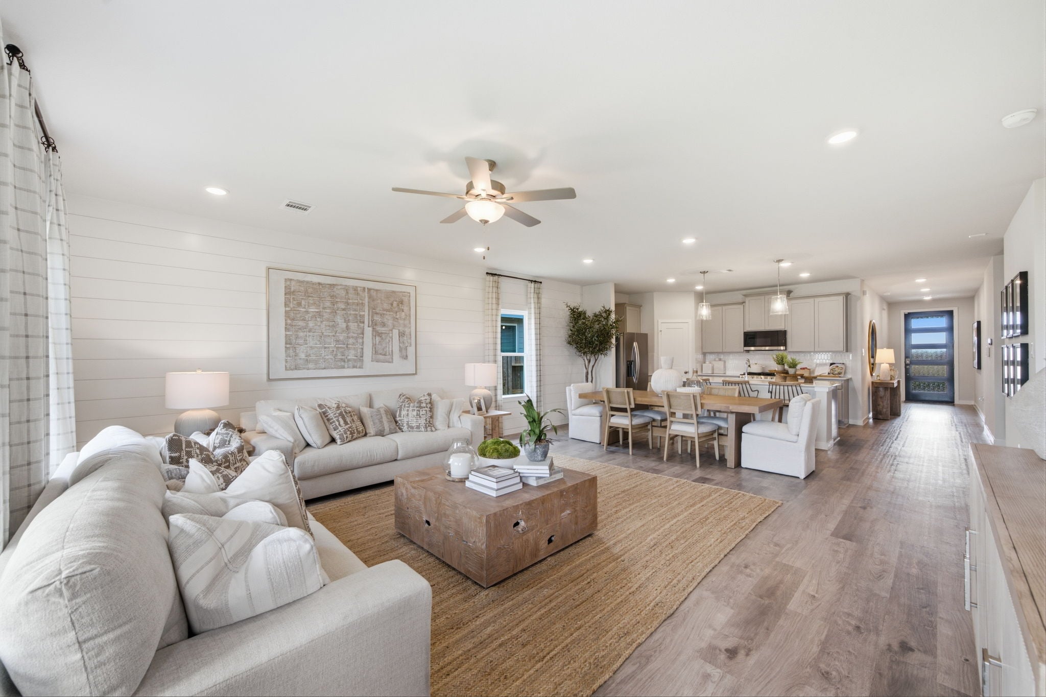 A large living room with a wood floor and a large chandelier.