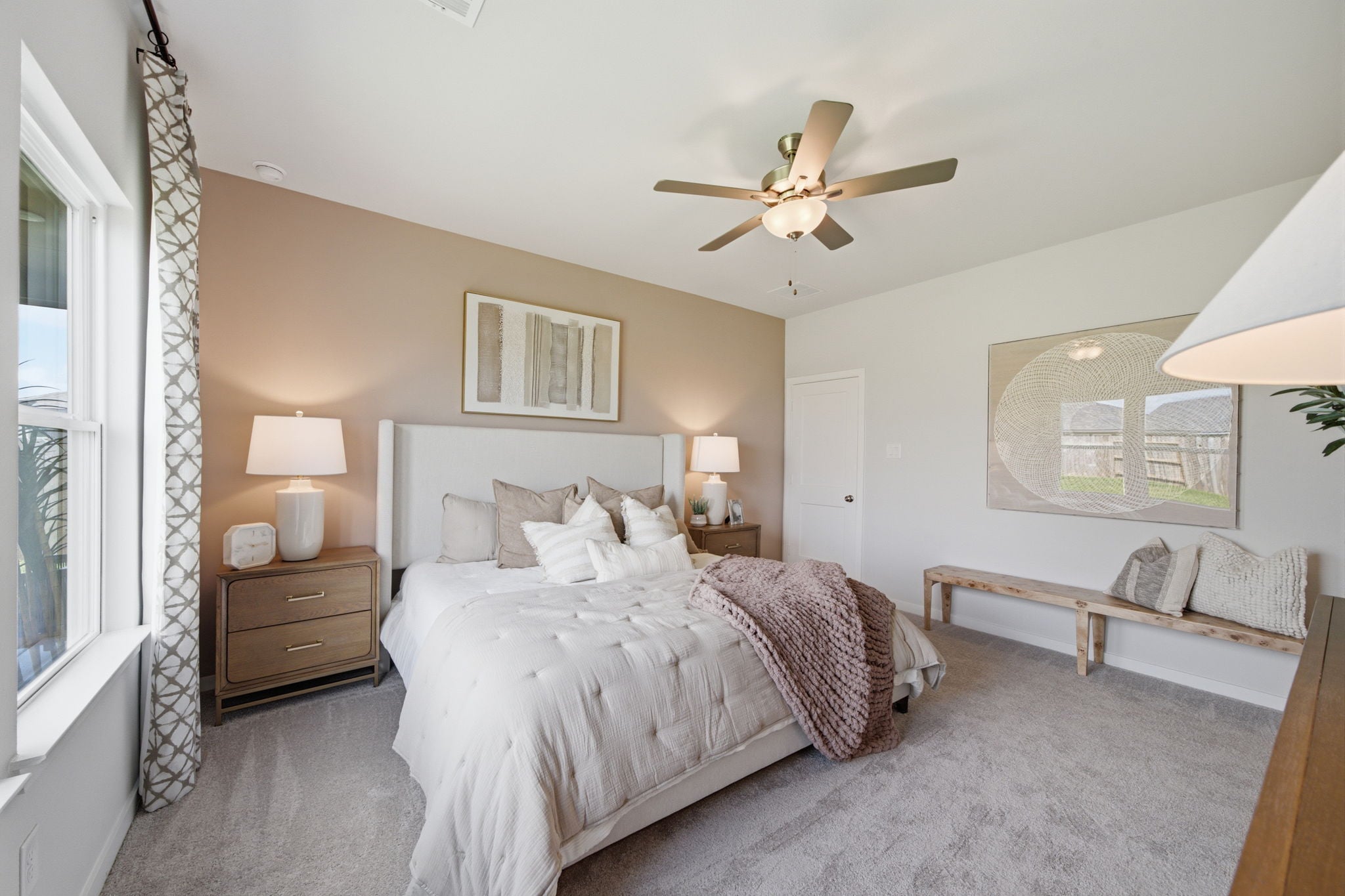 A bedroom with a bed and a fan.
