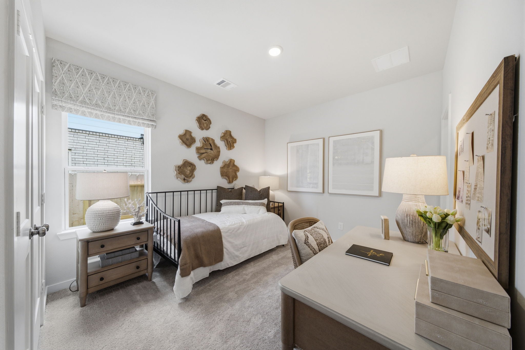 A bedroom with a bed desk and a lamp.