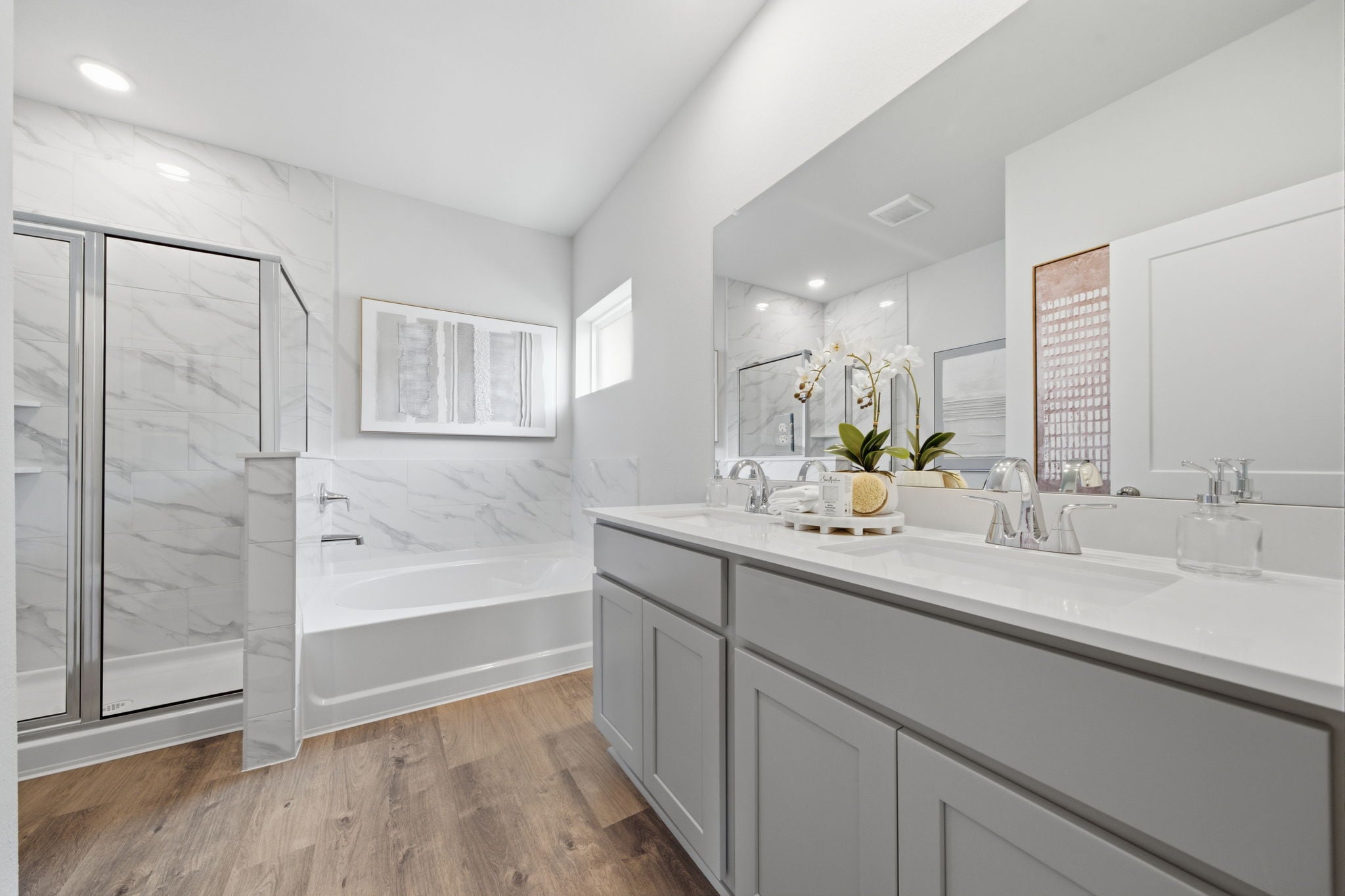 A bathroom with a tub sink and cabinets.