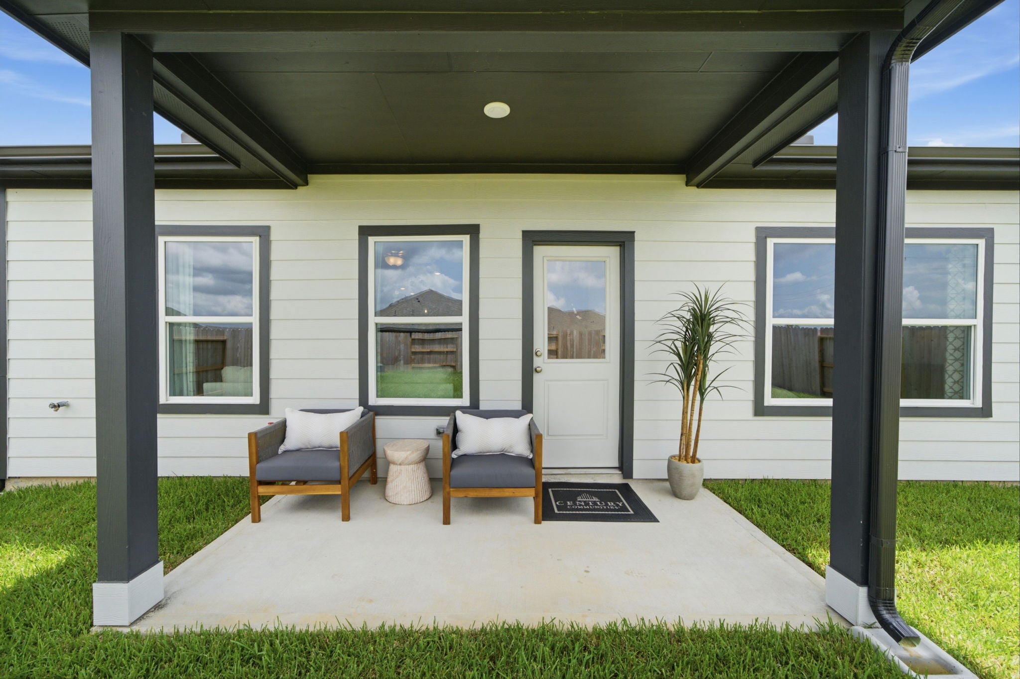 A house with a patio and a patio with a plant and a door.