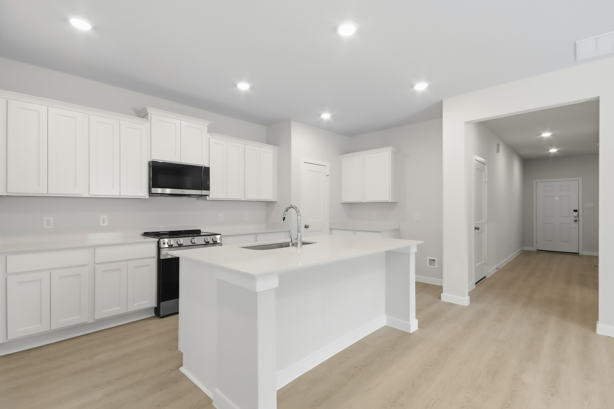 A kitchen with white cabinets.