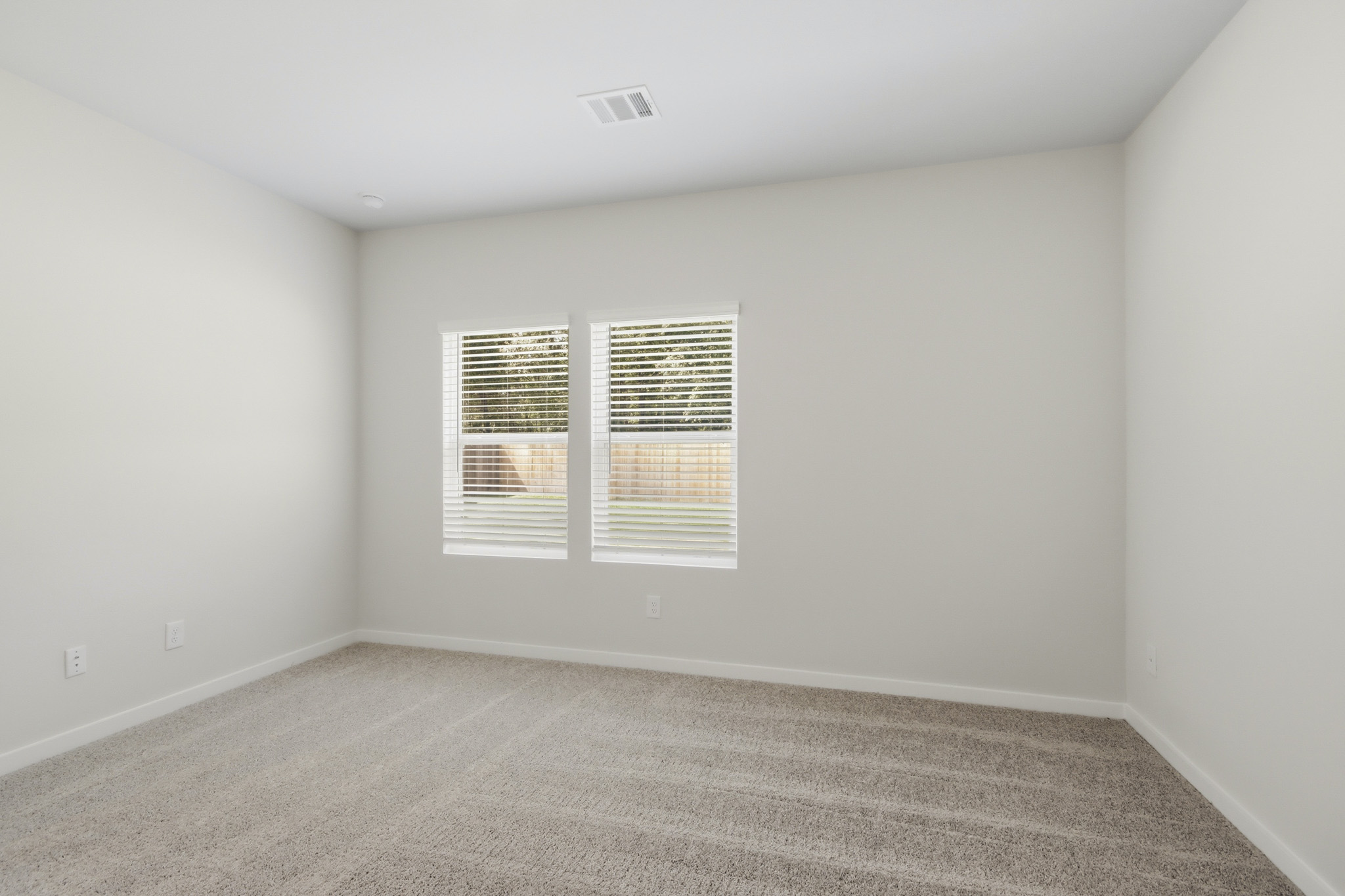 A room with a carpet and a window.