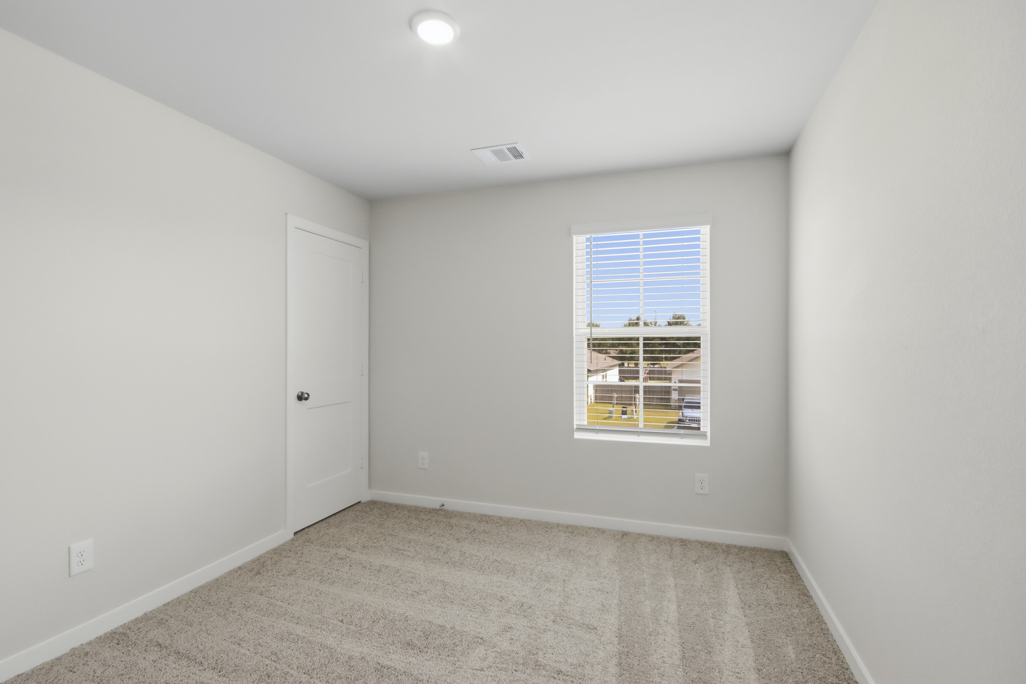 A room with a window and a carpet.