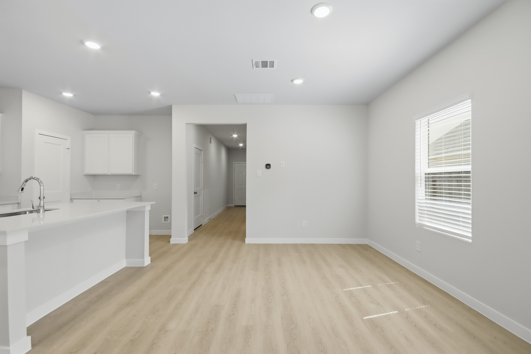 A large white room with a wood floor and a white counter top.