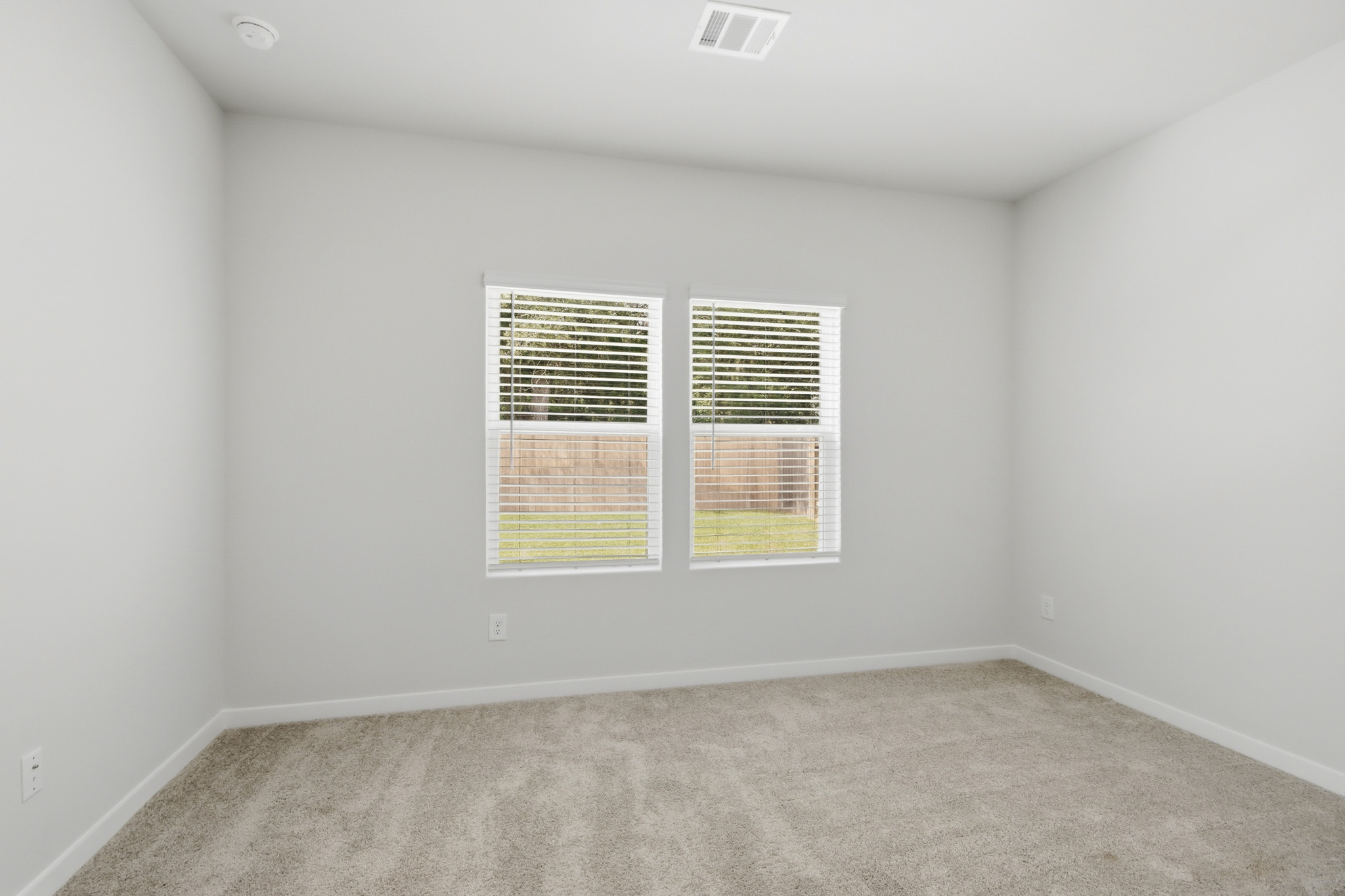 A room with a window and carpet.