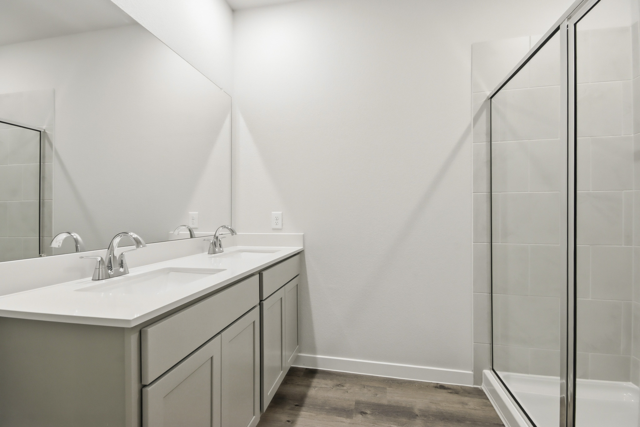 A bathroom with a sink and a shower unit.