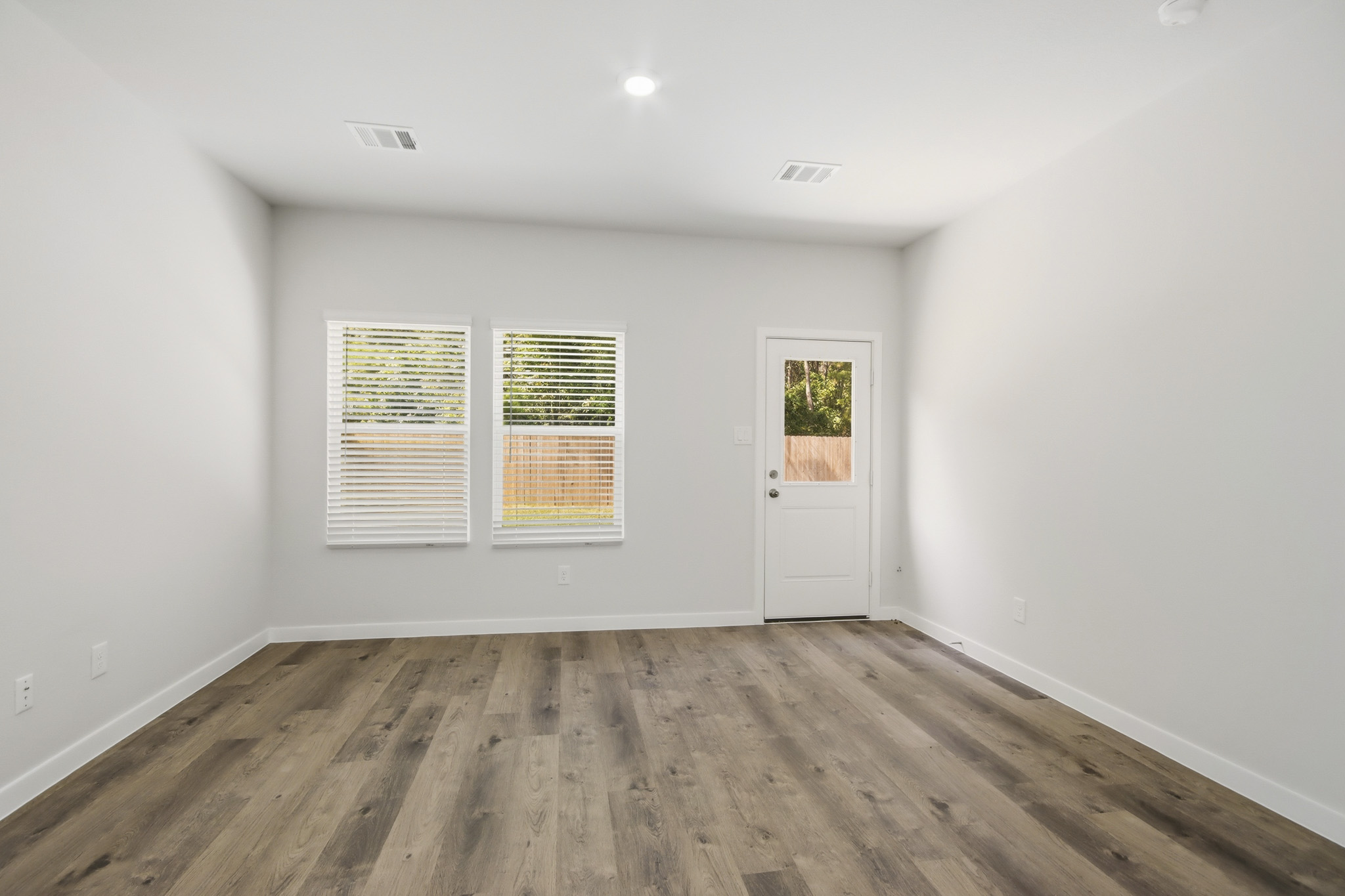 A room with a wood floor and white walls.