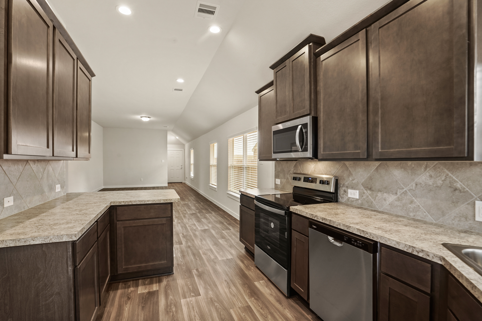 A kitchen with dark wood cabinets.