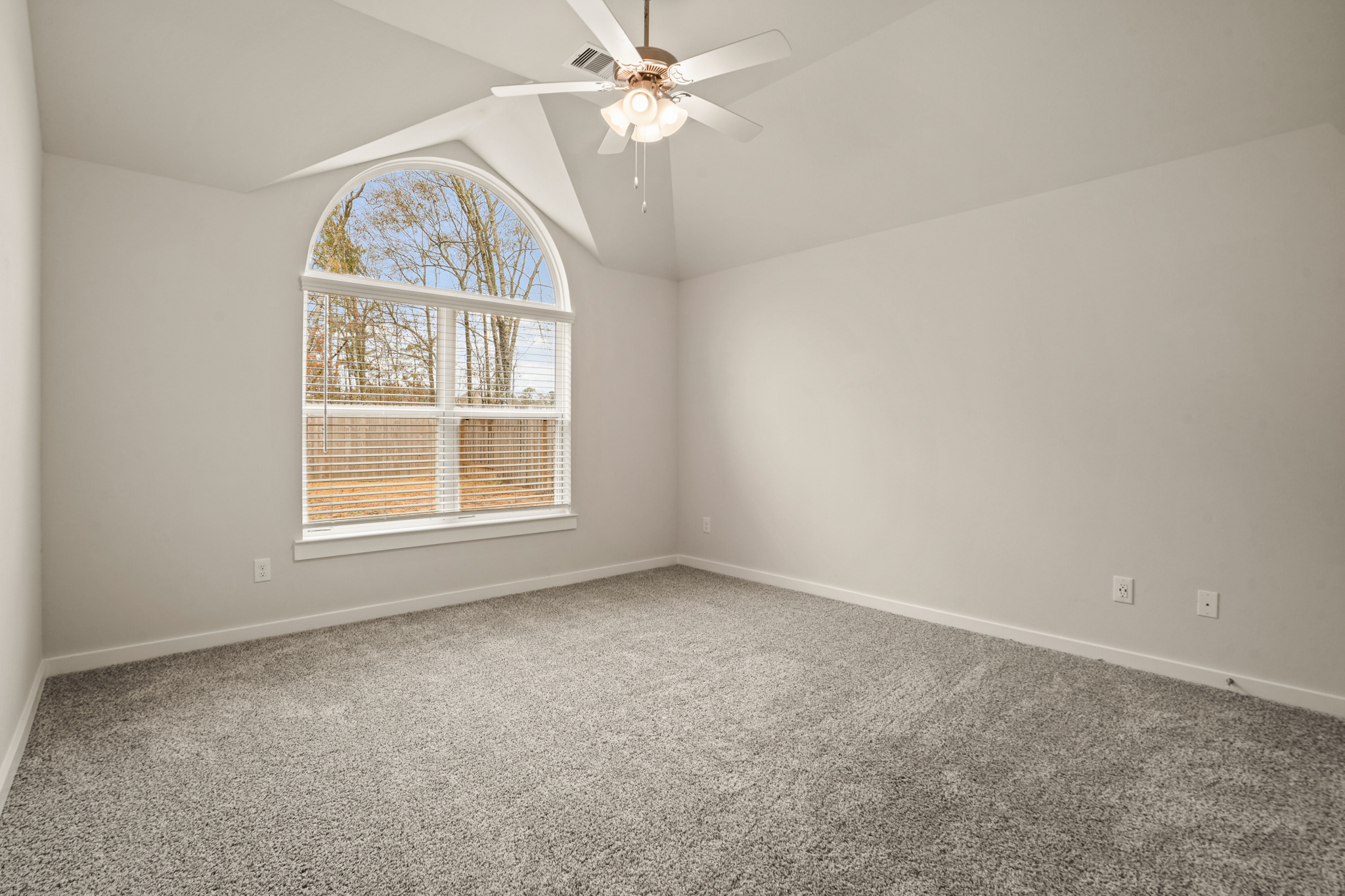 A room with a ceiling fan and a window.
