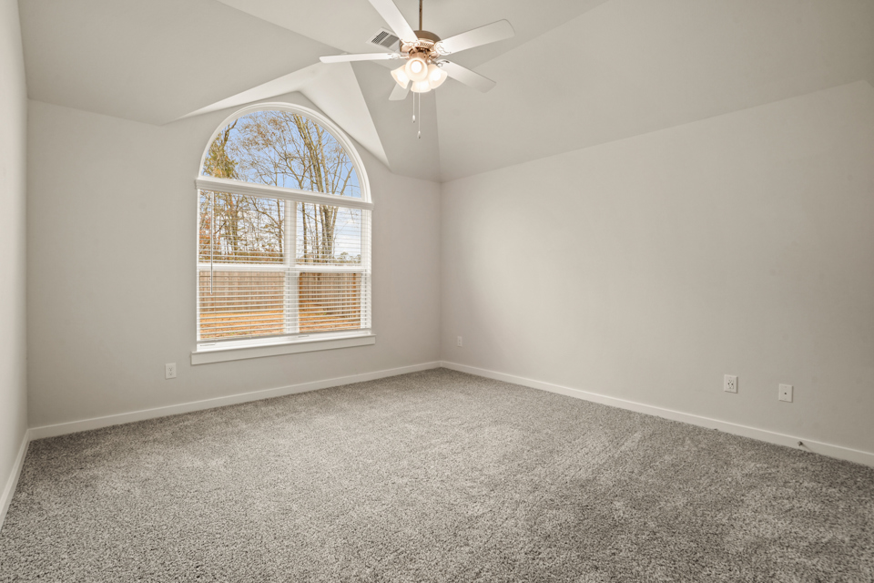 A room with a ceiling fan and a window.