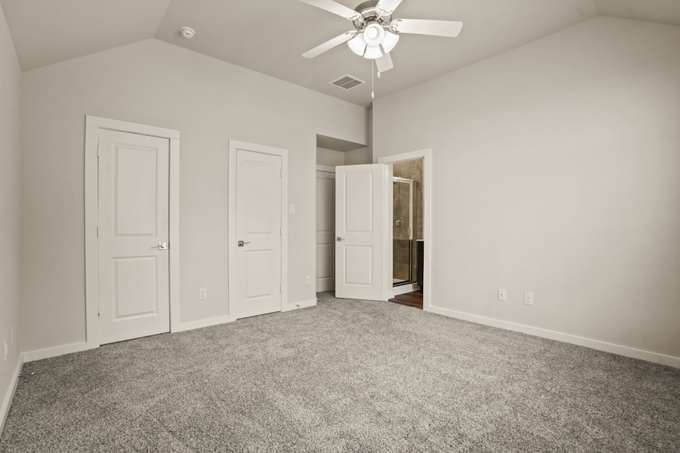 A room with white doors and a ceiling fan.