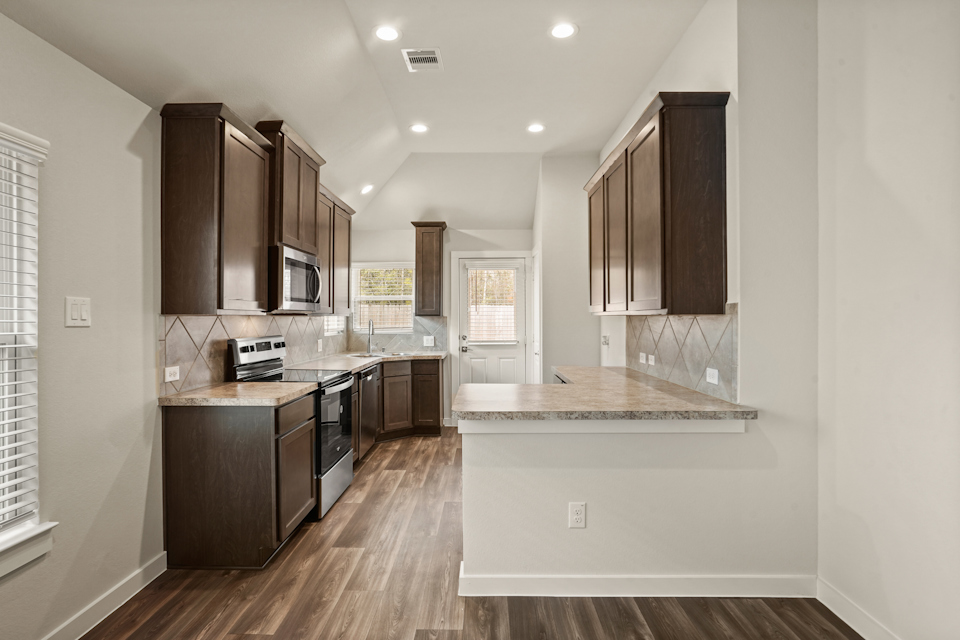 A kitchen with wooden cabinets.