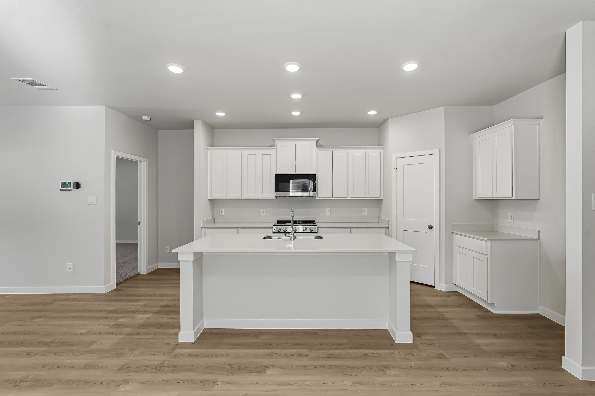 A kitchen with white cabinets.