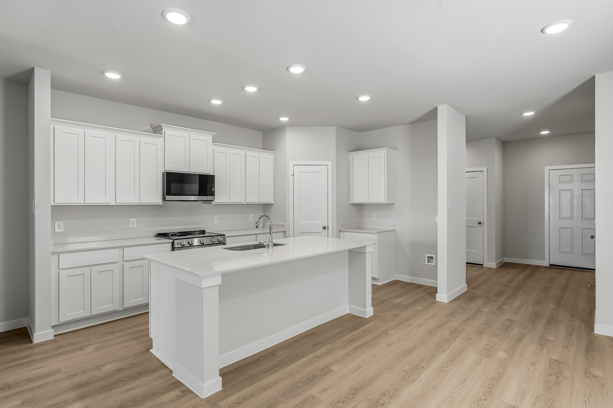 A kitchen with white cabinets.