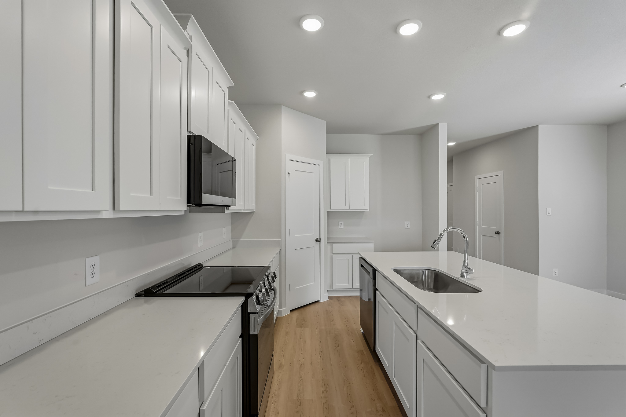 A kitchen with white cabinets.