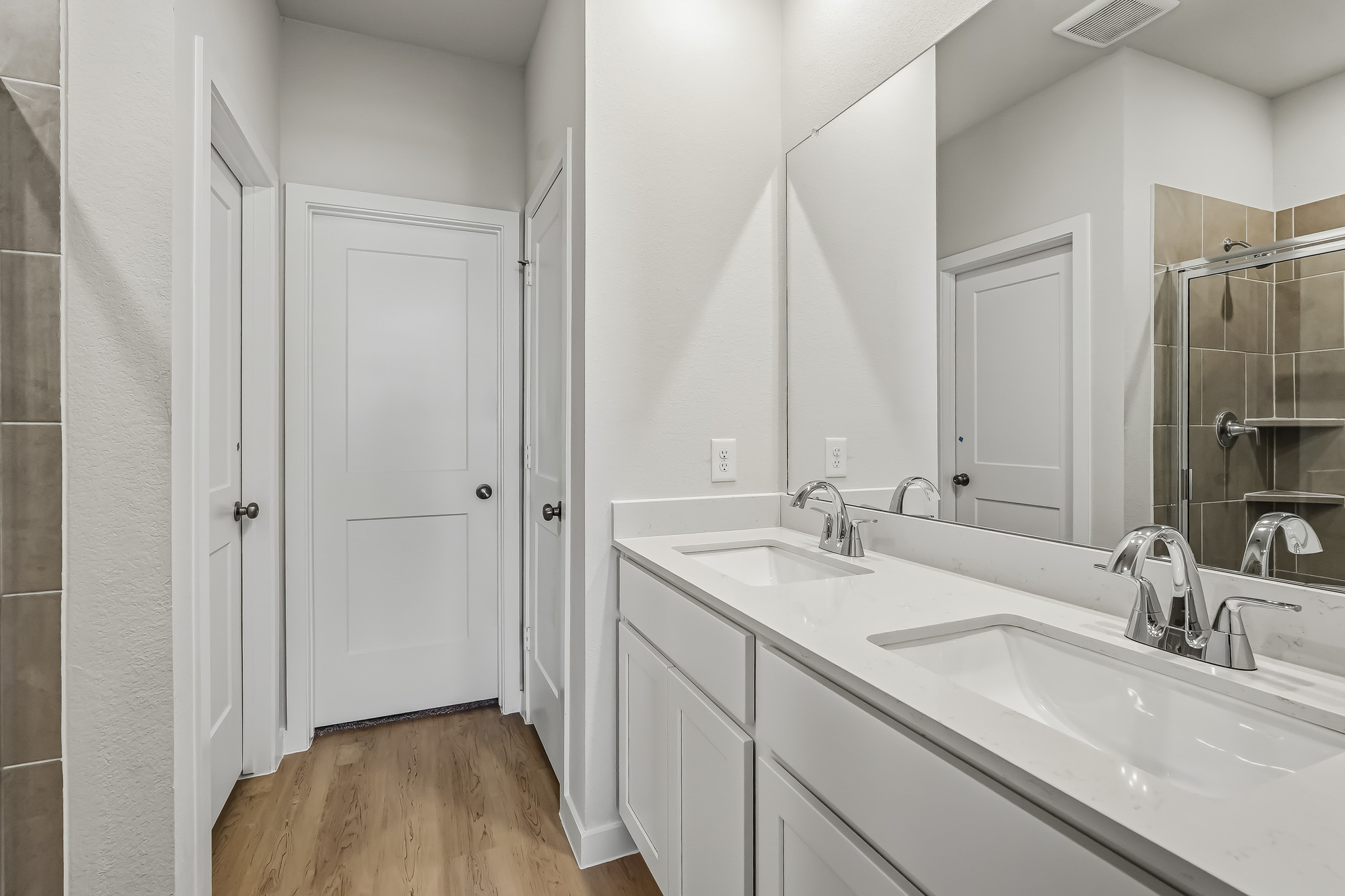 A bathroom with white cabinets.