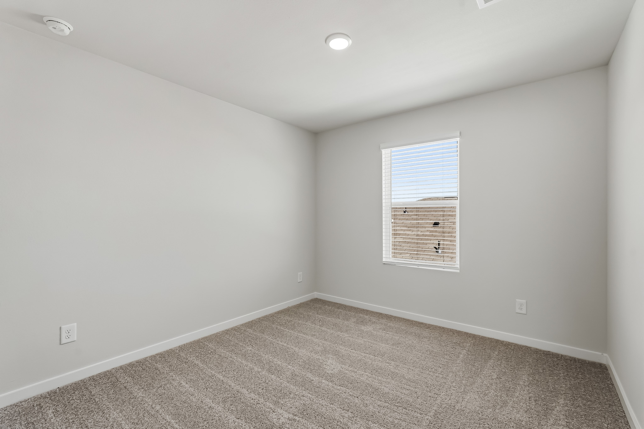 A room with a window and a carpet.