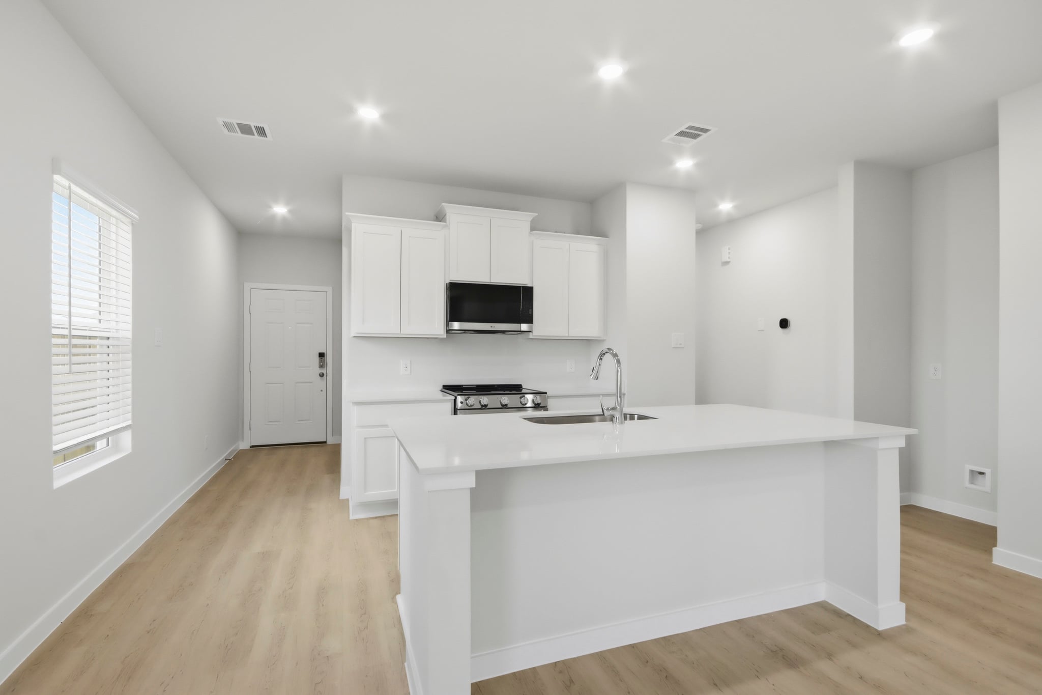 A kitchen with white cabinets.