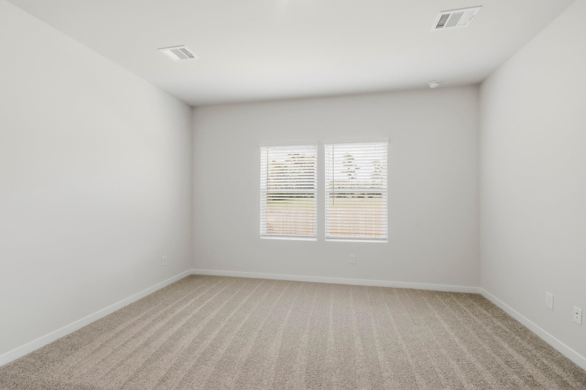A room with a carpet and a window.