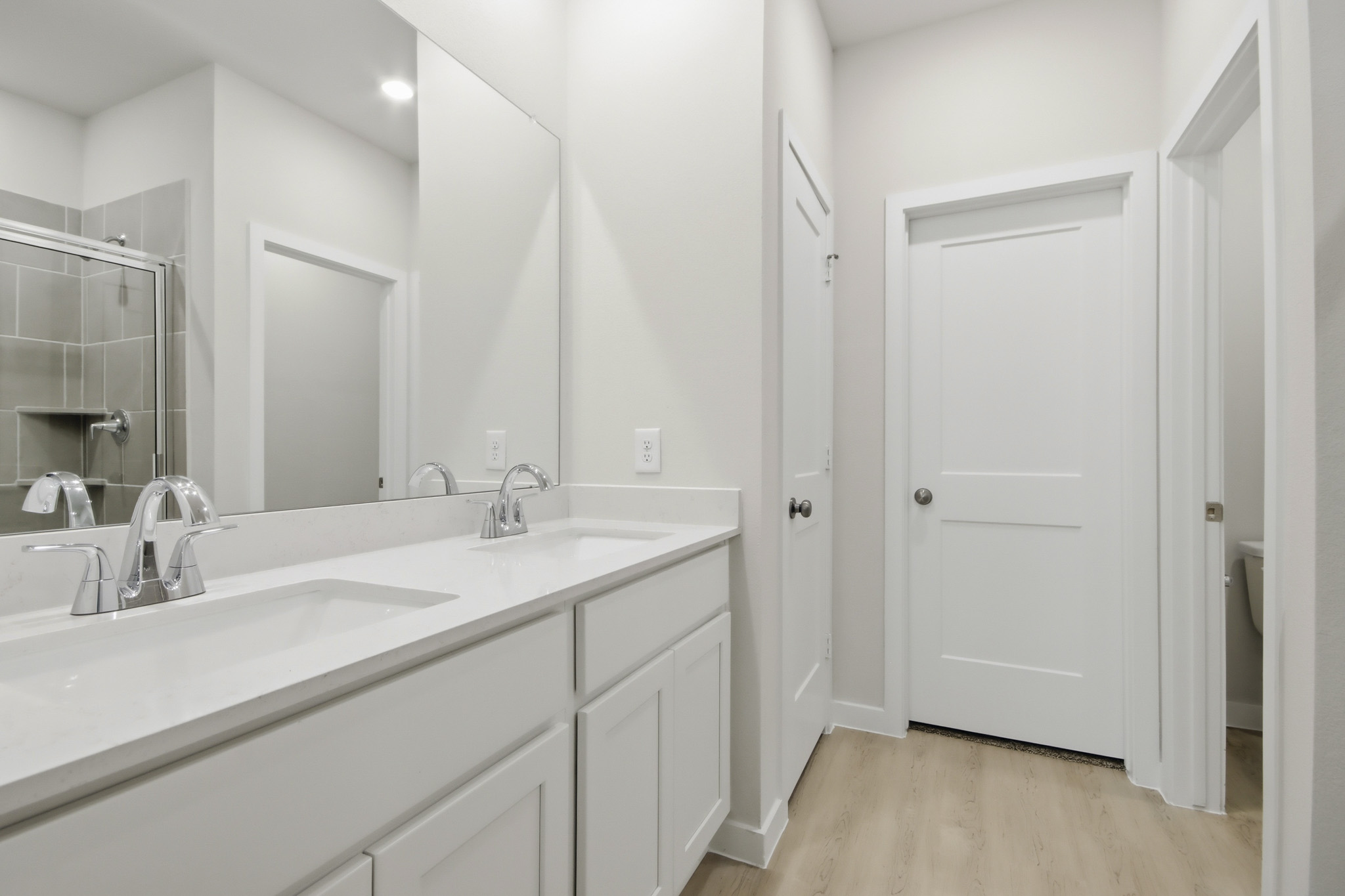A bathroom with white cabinets.