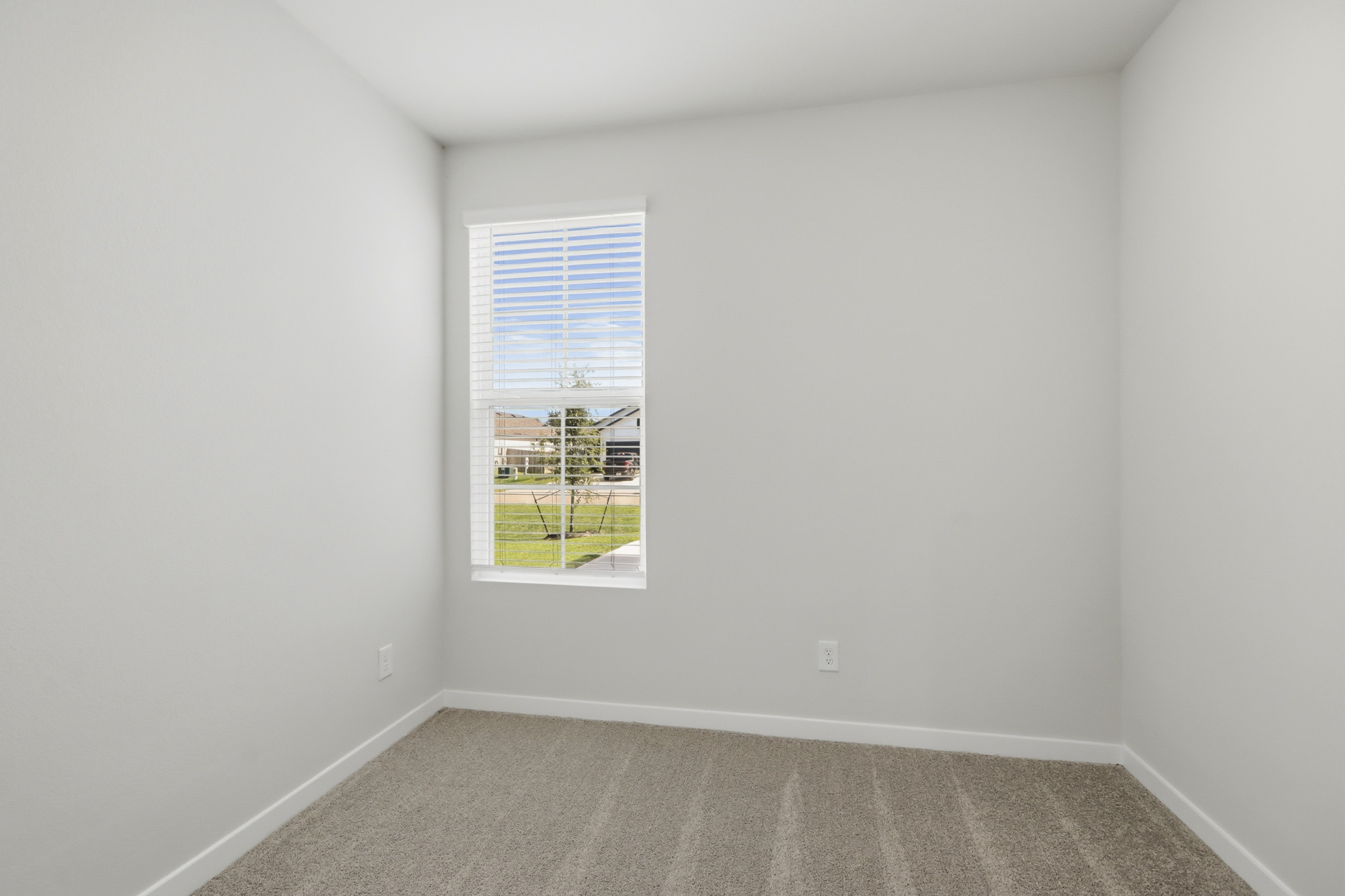 A room with a window and a rug.