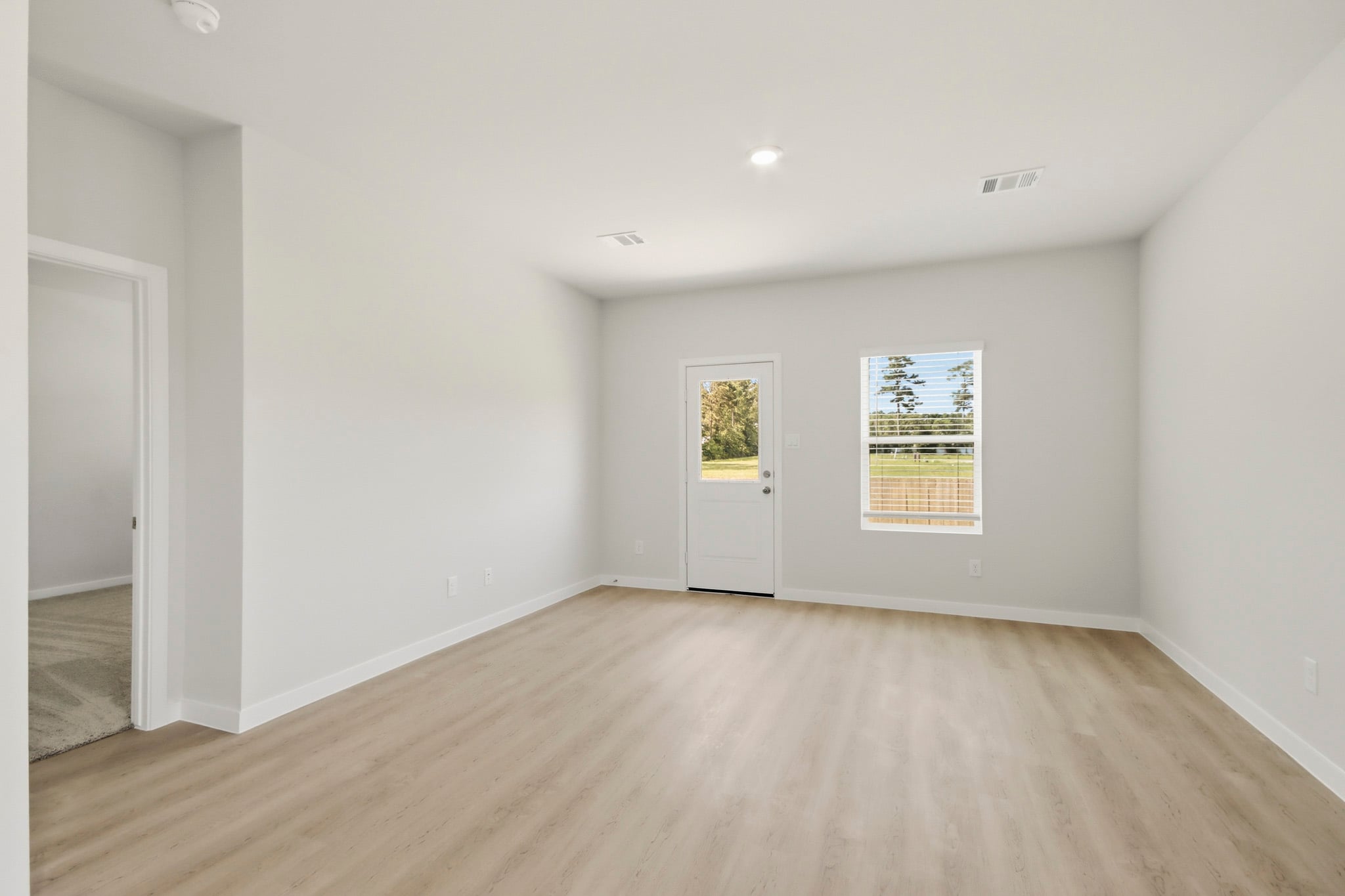 A room with a wood floor and white walls.