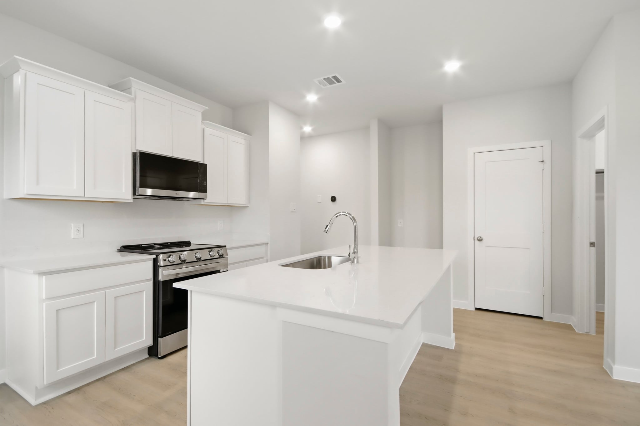 A kitchen with white cabinets.