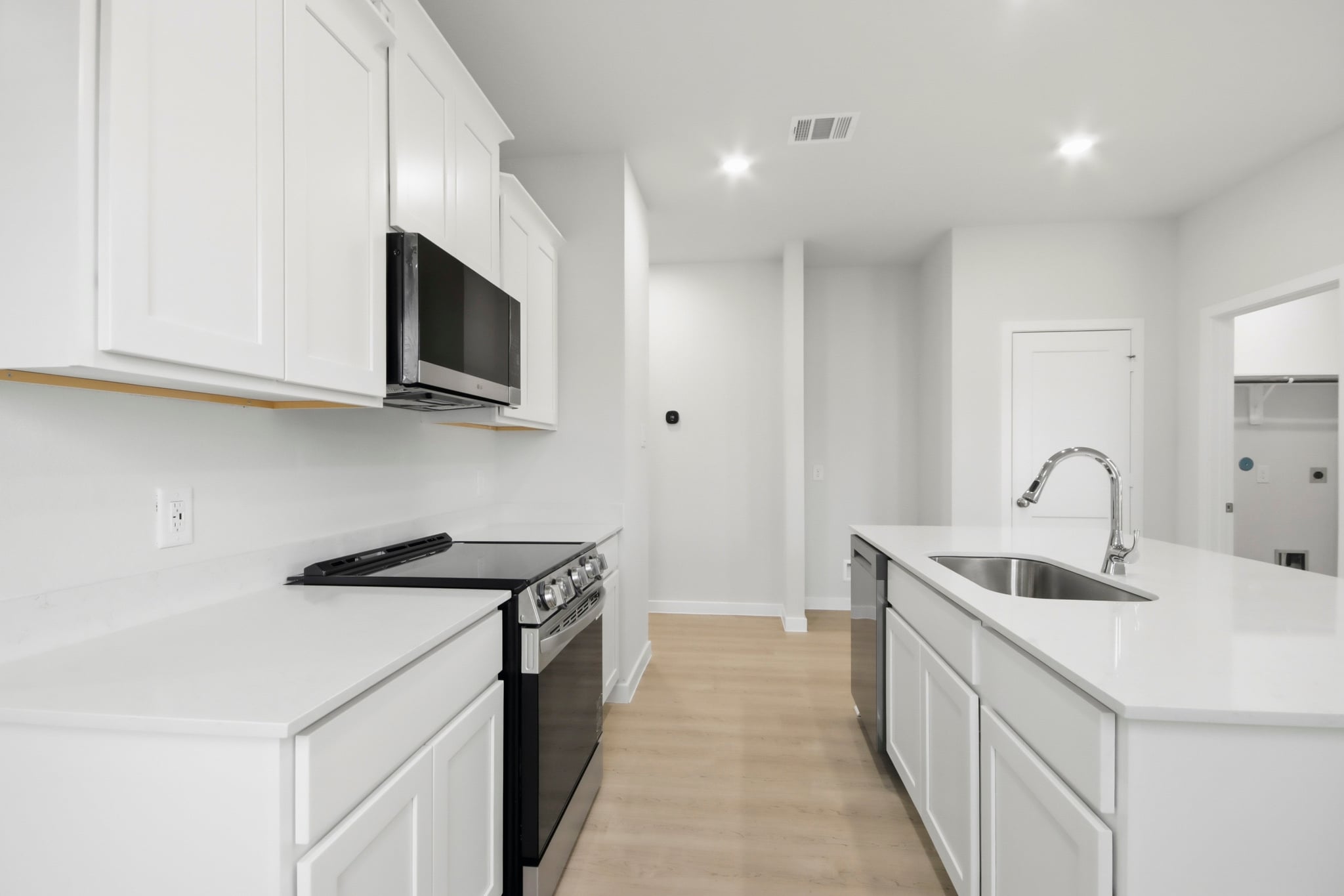 A kitchen with white cabinets.