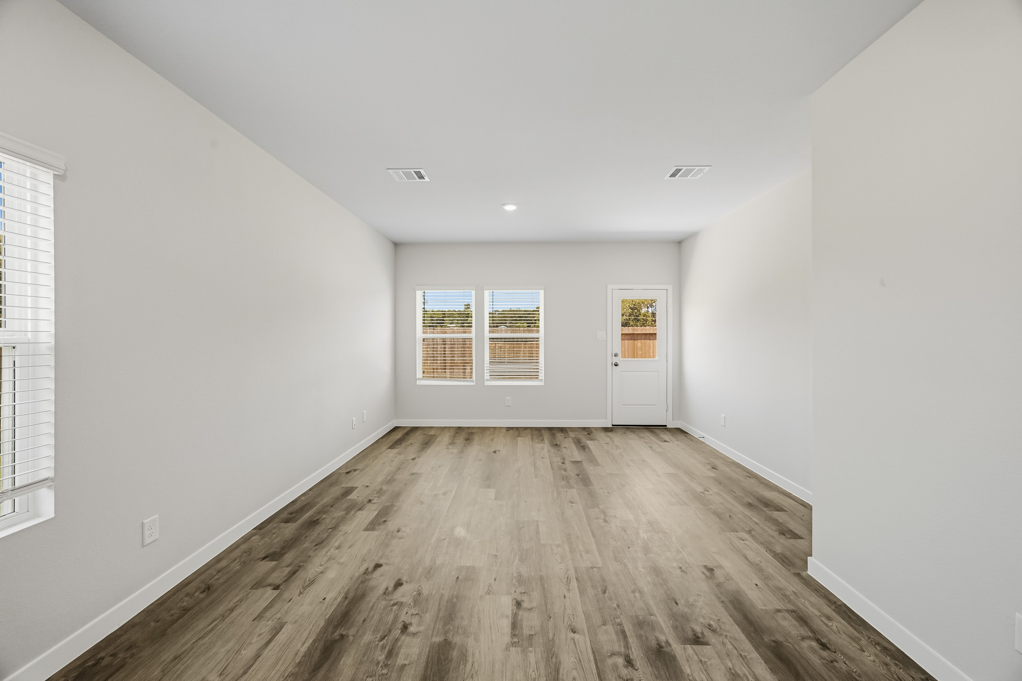A room with a wood floor and windows.