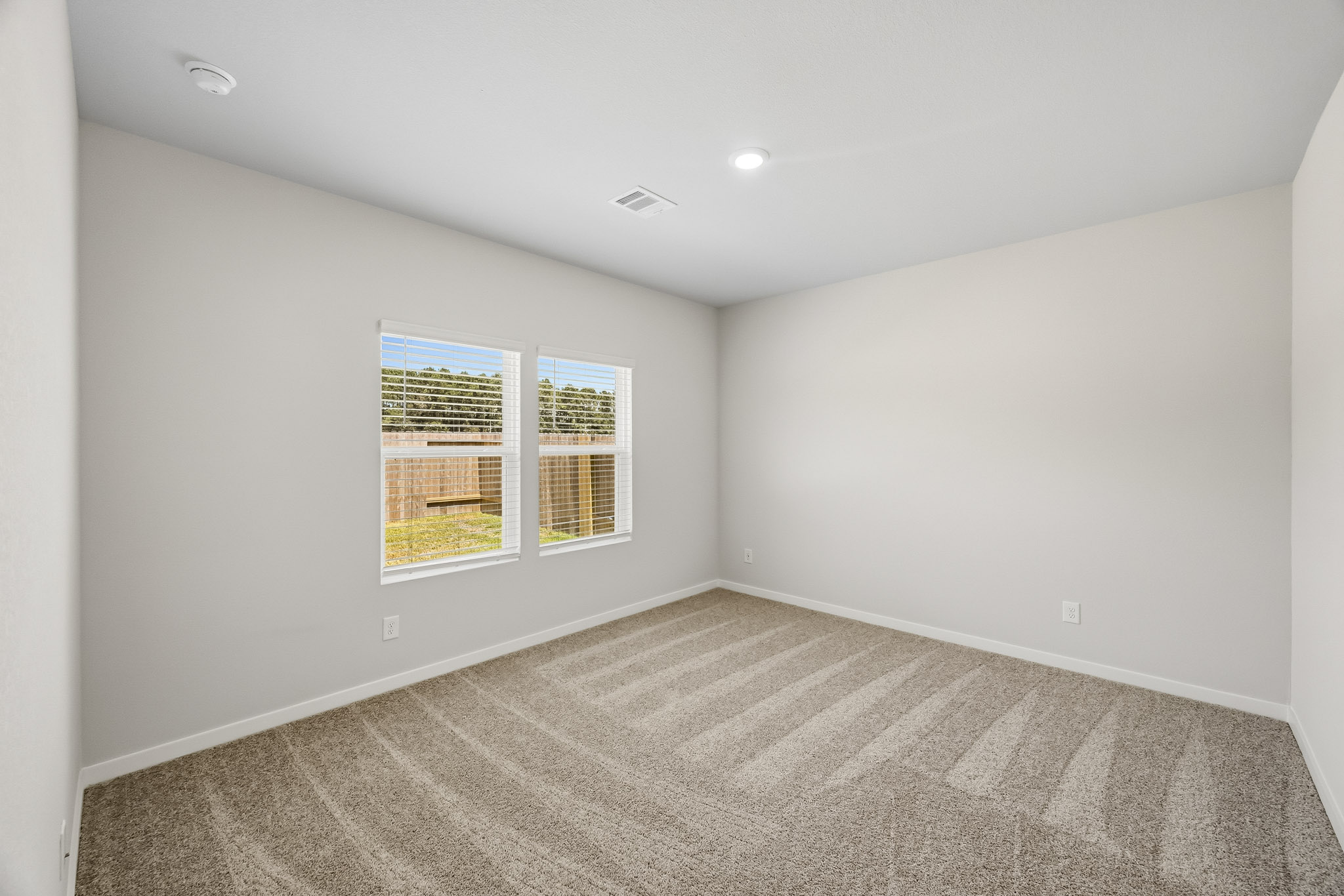 A room with a carpet and windows.