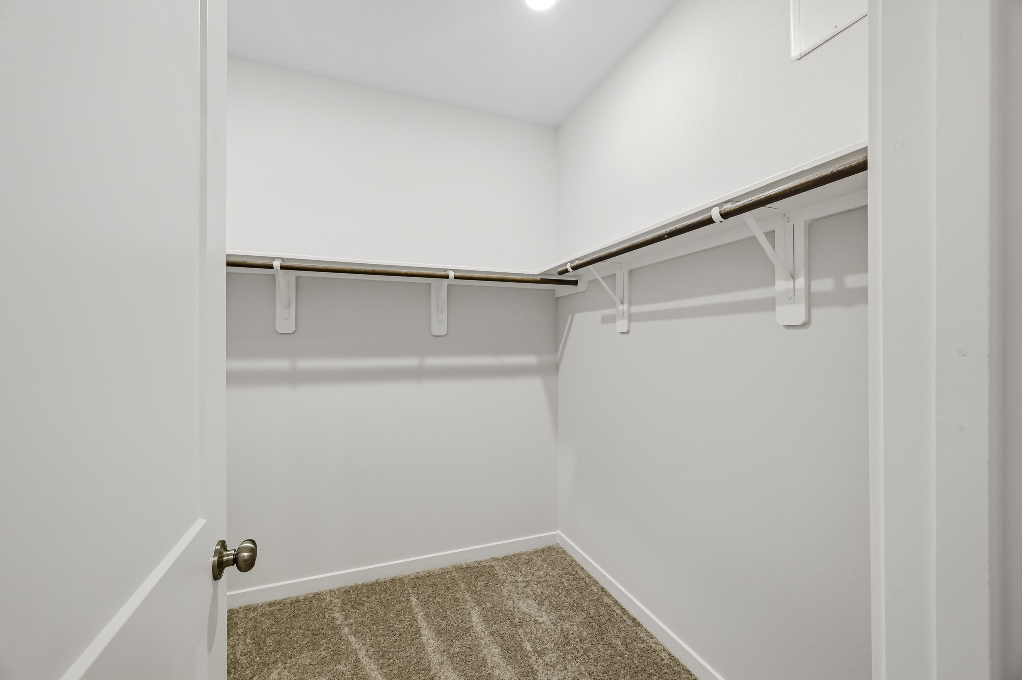 A white bathroom with a metal bar.