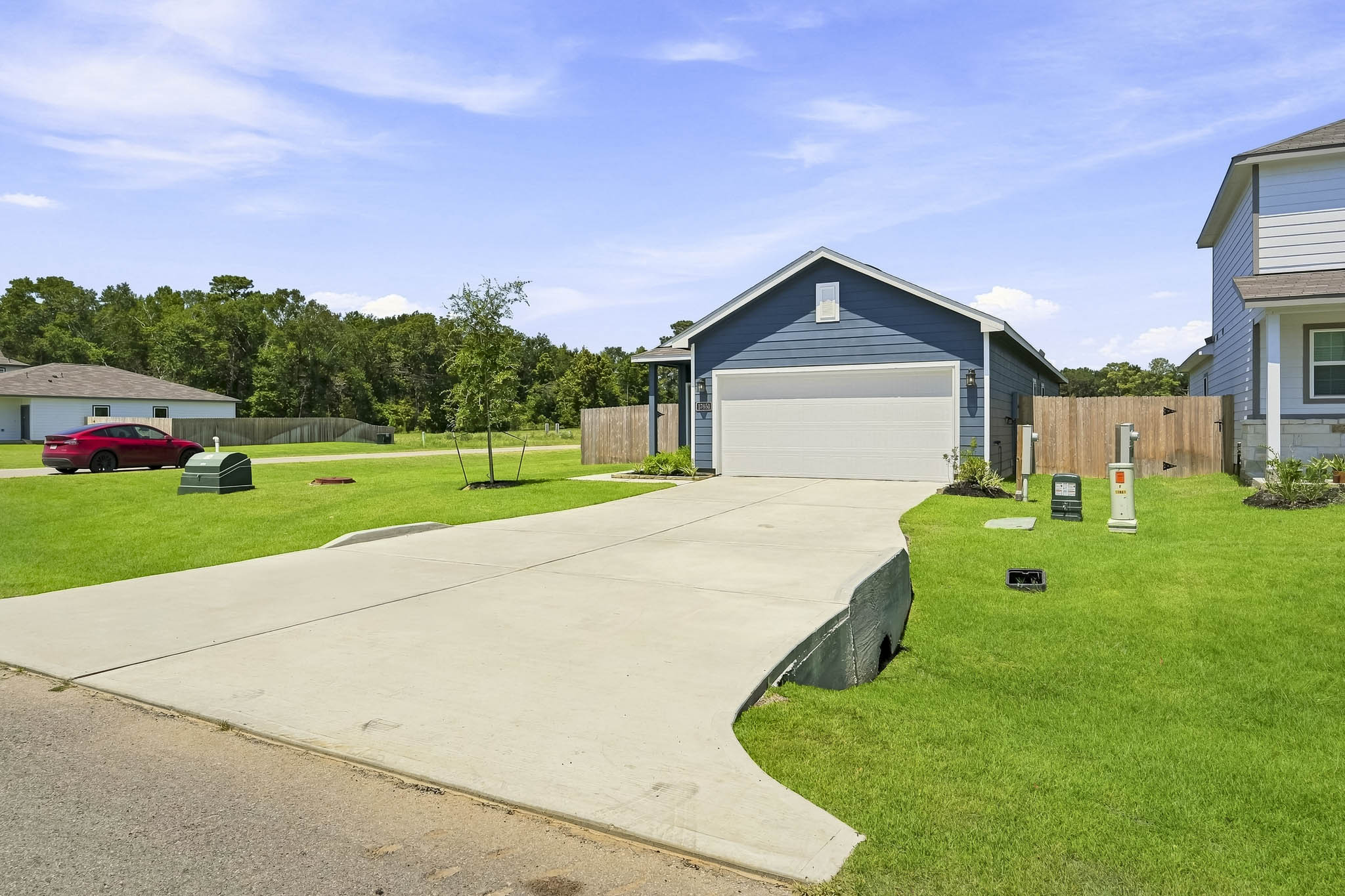 A backyard with a car parked in the driveway.