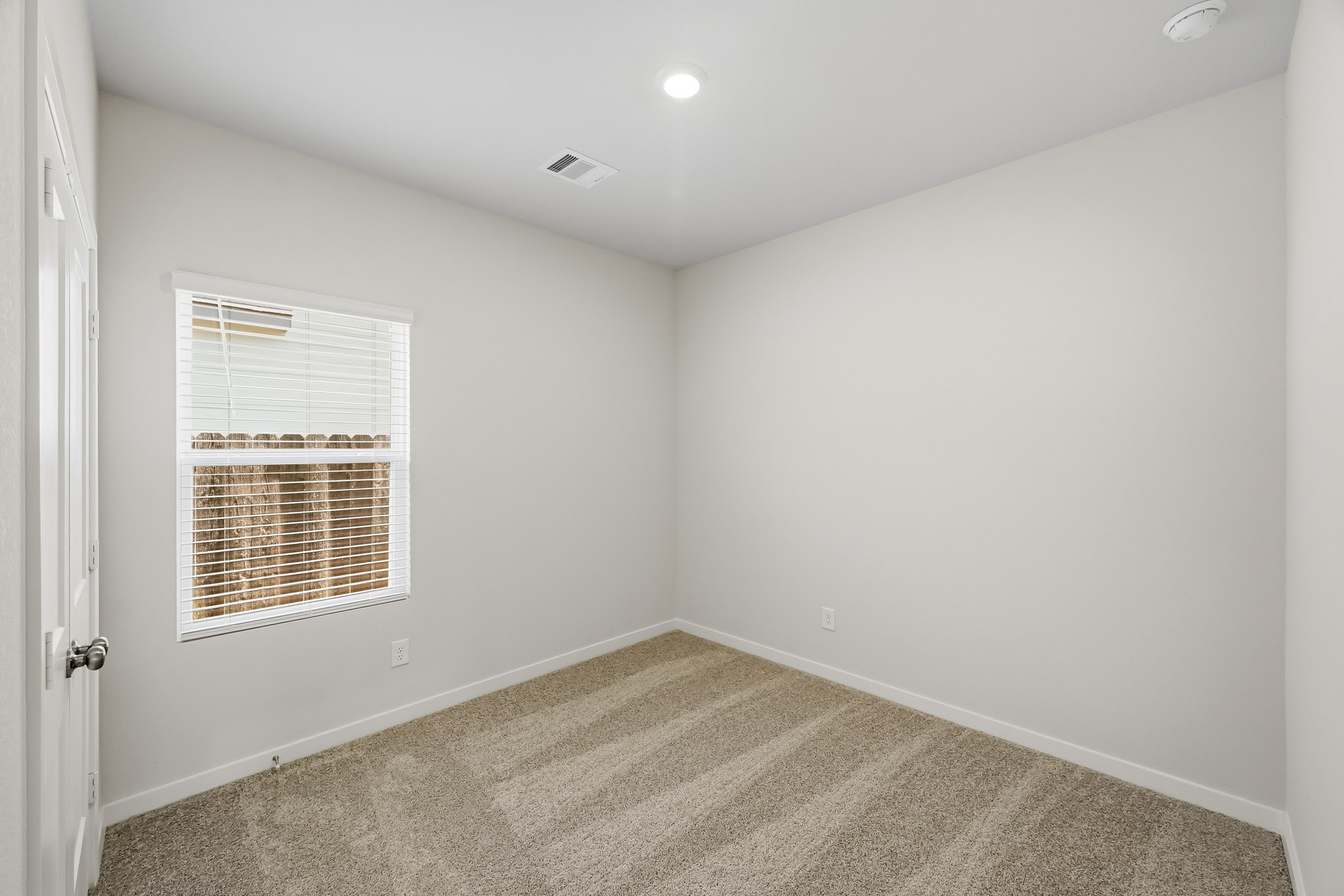 A room with a window and carpet.