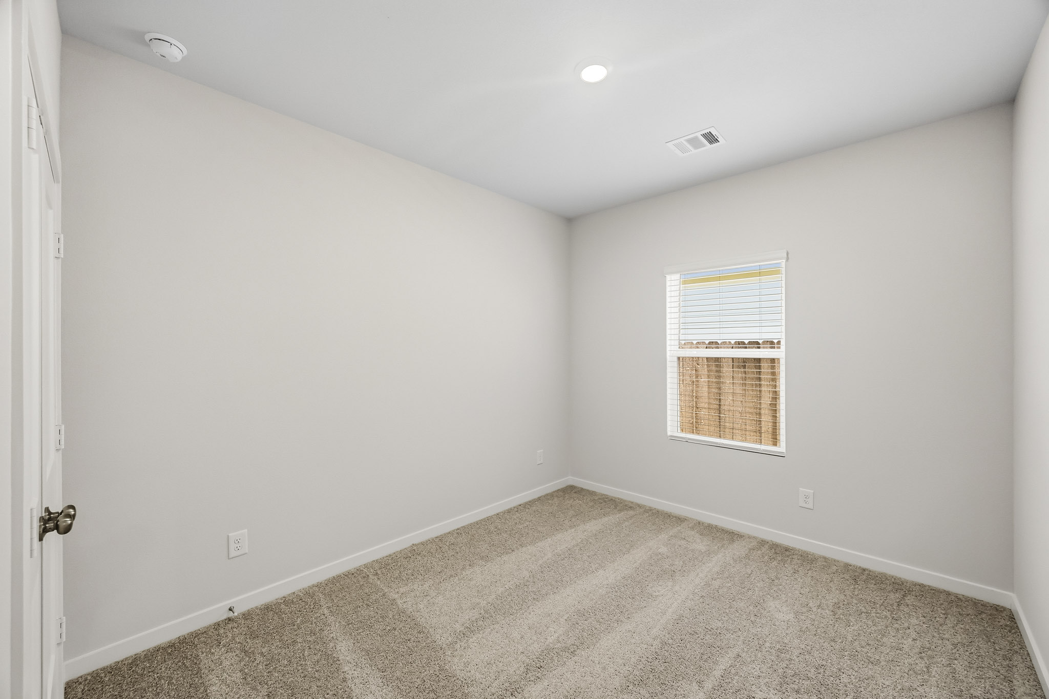 A room with a door and a rug.
