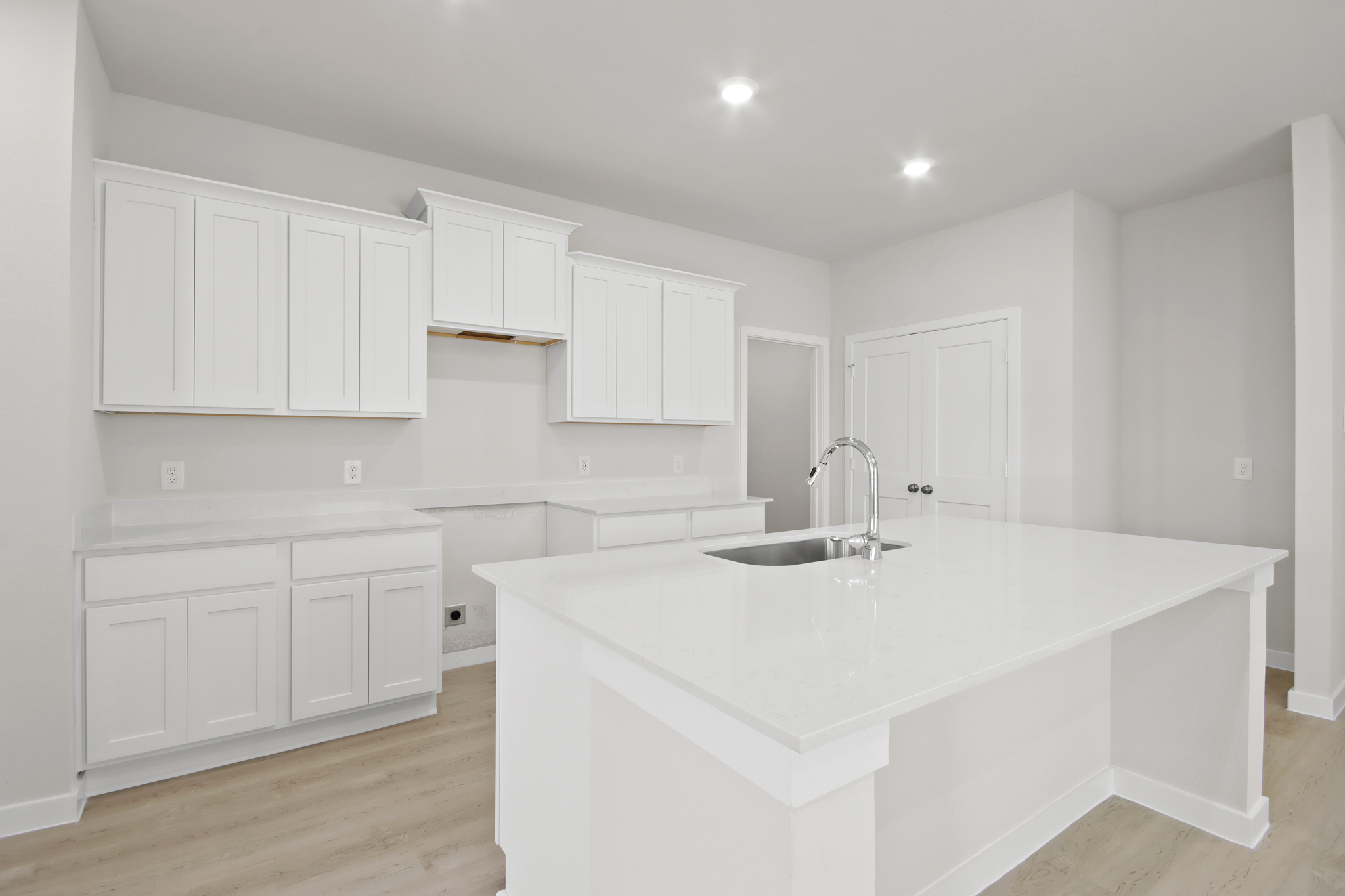 A kitchen with white cabinets.