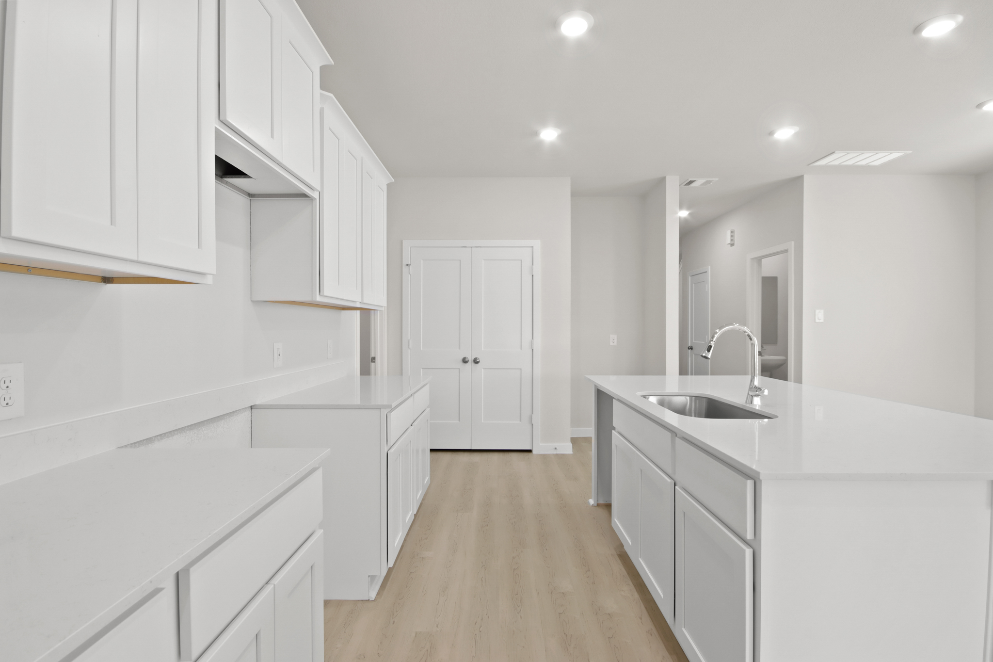 A kitchen with white cabinets.