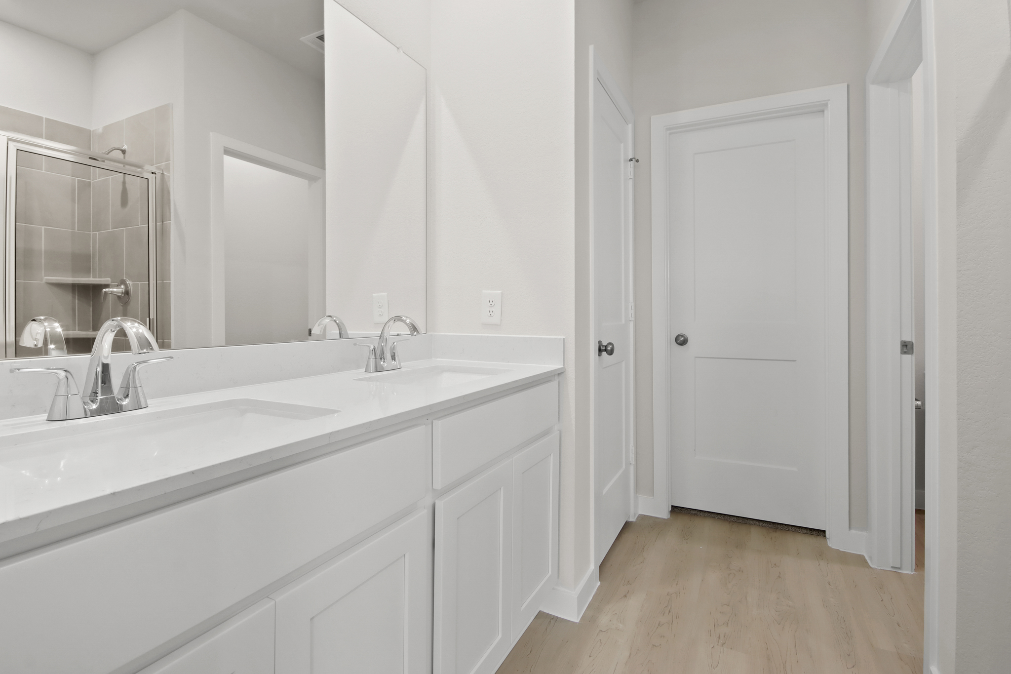 A bathroom with white cabinets.